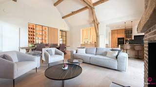 Bij ImmoFusion 7/7 “open huis” : klik op onze 3D-TOUR.<br />Ervaar vastgoed alsof je er zelf doorloopt!<br /><br />Welkom in deze prachtige gelijkvloerse nieuwbouwwoning in pastorijstijl, waar high-end afwerking, licht en ruimte centraal staan. Deze woning is bovendien ideaal voor een koppel dat in alle comfort volledig gelijkvloers wil wonen, zonder in te boeten aan praktische opbergruimte dankzij de ruime ondergrondse kelder.<br /><br />Van bij het betreden van de woning ervaar je meteen het gevoel van openheid en luxe. In de inkomhal bevinden zich het gastentoilet en de eerste ruime slaapkamer, die bovendien beschikt over een handig luik naar de zolder.<br /><br />De leefruimte vormt het absolute hart van de woning en imponeert door de uitzonderlijk hoge plafonds, die zorgen voor een ongeëvenaard ruimtelijk gevoel. Het warme karakter van houtaccenten en kwalitatief parket creëert een gezellige en stijlvolle sfeer. De houtstoof is hierbij een echte troef en maakt de winteravonden extra aangenaam.<br /><br />Aansluitend bevindt zich de moderne keuken met een groot en praktisch eiland, volledig uitgerust met een microgolf, oven, inductiekookplaat, dampkap en afwasmachine. Achter de keuken ligt een functionele berging die dienstdoet als wasruimte en voorzien is van alle nodige aansluitingen.<br /><br />Links van de leefruimte bevindt zich de tweede slaapkamer, met daarachter de comfortabele badkamer. Deze is uitgerust met een toilet, een ruim badkamermeubel met dubbele wastafel, een inloopdouche en praktische inbouwkasten.<br /><br />Het volledige pand is onderkelderd en beschikt over een grote, droge kelder die bovendien bereikbaar is via een lift, wat het wooncomfort aanzienlijk verhoogt en zorgt voor uitzonderlijk veel extra bergruimte. Buiten geniet je van een overdekt terras en een zeer ruime carport voor twee wagens, uitgerust met een laadpaal.<br /><br />Dankzij het uitstekende E3-peil geniet je bovendien van een vrijstelling van onroerende voorheffing gedurende vijf jaar. De woning is voorzien van zonnepanelen, een warmtepomp en vloerverwarming, wat zorgt voor een uiterst energiezuinig en toekomstgericht wooncomfort.<br /><br />Pluspunten:<br />- Gelijkvloerse high-end nieuwbouwwoning in pastorijstijl<br />- Ideaal voor comfortabel gelijkvloers wonen met veel opbergruimte<br />- Zeer lichtrijk met uitzonderlijk hoge plafonds in de leefruimte<br />- Volledig onderkelderd met lift<br />- Energiezuinig: E3-peil, zonnepanelen en warmtepomp<br />- Vloerverwarming in de volledige woning<br />- Overdekt terras en carport voor 2 wagens met laadpaal<br />- Warme en luxueuze afwerking met hout en parket<br /><br /><span>Maatregelen opgenomen in het Maatregelenregister: nee</span><br /><br />Voor een bezichtiging ter plaatse of meer info, bel ons op 078/78.78.70, of kom gewoon binnen op ons kantoor, steeds welkom!