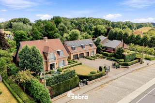 Deze stijlvolle villa bevindt zich op een uitzonderlijk perceel van bijna 3.000 m², op amper vijf minuten fietsen van het centrum van Meulebeke. Een eigendom waar architectuur, wooncomfort en duurzaamheid elkaar naadloos ontmoeten.<br /><br />De villa onderscheidt zich door haar sterke energetische prestaties, met onder meer 44 zonnepanelen, een laadpaal, een regenwatercapaciteit van 18.000 liter en een EPC dat nagenoeg label B behaalt. Praktische troeven zoals twee inpandige garageplaatsen, een ruime kelder met onder meer een wijnkelder en een kruipkelder benadrukken de uitzonderlijke kwaliteit en degelijkheid van deze woning.<br /><br />Wat deze eigendom bijzonder maakt, is haar veelzijdigheid. De doordachte indeling met twee afzonderlijke inkomdeuren biedt tal van mogelijkheden voor wie wonen en werken wil combineren, klanten in alle discretie wil ontvangen of op zoek is naar een oplossing voor kangoeroewonen of een zorgwoning.<br /><br />Binnen wordt u verwelkomd in een lichtrijk interieur waar ruimte, tijdloze architectuur en hoogwaardige afwerkingsmaterialen centraal staan. Grote raampartijen brengen het omliggende groen volledig tot leven en creëren een harmonieuze verbinding tussen binnen en buiten. <br /><br />Op het gelijkvloers vloeien de verschillende leefruimtes harmonieus in elkaar over. Een stijlvolle bureauruimte, een ruime woonkamer, een afzonderlijke tv-kamer en een lichtrijke veranda en de keuken geniet van een prachtig zicht op de tuin.<br /><br />De villa beschikt over vier volwaardige slaapkamers met maatwerkkasten en twee luxueuze marmeren badkamers, beide uitgerust met een ligbad en een inloopdouche.<br /><br />Ook buiten straalt deze eigendom rust en exclusiviteit uit. De fraai aangelegde tuin met beplanting, een strak onderhouden gazon en een sierlijke koivijver vormt een oase van privacy. De royale aanbouw fungeert als een volwaardige leefruimte die het hele jaar door een vloeiende overgang creëert tussen wonen en genieten van het buitenleven.<br /><br />Een uitzonderlijke residentie waar karakter, comfort en functionaliteit samenkomen op een toplocatie.<br /><br /><strong>Ook wild geworden van deze thuis?<br />Twijfel dan niet langer en leg vandaag nog uw bezoek vast!</strong>