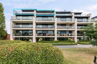 <p><strong>Unieke penthouse met adembenemend uitzicht in parkdomein te Putte.</strong></p>
<p><strong>Exclusief wonen in residentie Parc Alice Nahon:<br /></strong>Ontdek deze luxueus afgewerkte penthouse (bouwjaar 2019) in het prestigieuze parkproject <em>residentie Parc Alice Nahon</em>, gelegen op wandelafstand van het centrum van Putte. Deze unieke eigendom biedt een ongeëvenaarde combinatie van <strong>rust, ruimte, licht en groen</strong> – <br />de perfecte harmonie tussen comfort en natuur.</p>
<p><strong>Kenmerken:<br /></strong>Bewoonbare oppervlakte: 140 m²<br />Terras: 86 m² rondom rond met panoramisch uitzicht<br />Slaapkamers: 2 + volledig geïnstalleerde bureau (<strong>mogelijk in te richten als 3de slaapkamer</strong>)<br /><strong>Prijs penthouse inclusief Privéberging: </strong>€699.000<br /><strong>Verplichte aankoop 3 autostaanplaatsen</strong>: €60.000<br /><strong>Totale prijs</strong>: €759.000<br /><br />Deze penthouse biedt een <strong>exceptionele lichtinval</strong> dankzij de grote raampartijen en een open indeling. De ruime leefruimte is afgewerkt met hoogwaardige materialen en voorzien van een <strong>gezellige gashaard</strong> met Dekton tablet, perfect voor knusse avonden.<br />De <strong>open keuken</strong> is volledig uitgerust met topkwaliteit Miele-apparatuur waaronder een industriële stoomoven, heteluchtoven en een ingewerkte inductiekookplaat in een stijlvol Dekton werkblad. Ook de spoelbak en dampkap (Novy) zijn volledig geïntegreerd in dit strakke design.<br />De badkamer is voorzien van een <strong>ruime inloopdouche</strong> en comfortabele inrichting. Het hele appartement is energiezuinig (E-peil: 41, A-label), voorzien van <strong>vloerverwarming</strong>, <strong>drievoudige beglazing</strong> en <strong>airconditioning</strong>.</p>
<p><strong>Comfort en technologie:<br /></strong>Volledig ingebouwde bureau met maatwerkkasten en lades (voorheen 3de slaapkamer/hobbyruimte)<br /><strong>Automatische zonneluifel</strong> en sfeervolle buitenverlichting op het terras<br /><strong>Automatische screens</strong> in keuken, leefruimte en gang<br /><strong>Airco-installatie</strong> in het hele appartement<br /><strong>EK volledig conform</strong> het AREI<br /><strong>Beveiligde ondergrondse parkeergarage</strong> met 3 ruime staanplaatsen, privéberging, badge- en afstandsbedieningssysteem<br /><strong>Gemeenschappelijke voorzieningen</strong>: fietsenstalling, bezoekersparking, glas- en huisvuilcontainers, laadpaal voor elektrische voertuigen</p>
<p><strong>Ligging en bereikbaarheid:<br /></strong>Deze penthouse ligt <strong>op een rustige locatie midden in een aangelegd park</strong>, vlakbij winkels, scholen en het centrum van Putte. <br />Vlotte verbinding naar omliggende steden dankzij nabijheid van de R6 en E19.<br /><br /><strong>Interesse?<br /></strong>Laat je betoveren door de unieke ligging, het panoramisch terras, de luxueuze afwerking en het ongeëvenaarde wooncomfort.<br />Voor een bezichtiging of meer informatie, contacteer onze vastgoedverantwoordelijke via <strong>0492/406156</strong>.</p>