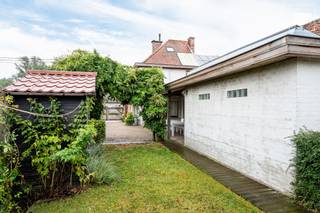 Deze halfopen bebouwing is gelegen op een bijzonder aangename en groene locatie in Drongen, waar rust en privacy centraal staan. <br /><br />Tegelijk bevinden winkels, scholen en belangrijke invalswegen zich op korte afstand, waardoor de woning een uitstekende combinatie biedt van rustig wonen en een vlotte bereikbaarheid.<br /><br />De woning werd in het verleden uitgebaat als B&amp;B en beschikt over vier volwaardige slaapkamers, elk voorzien van eigen sanitair met douche, toilet en airconditioning.<br /><br />De indeling biedt hierdoor heel wat mogelijkheden voor een gezin, maar eveneens voor wie extra ruimte zoekt voor gasten, thuiswerk of een andere invulling.<br /><br />De keuken sluit aan op de praktische wasplaats, met aansluitend een riante garage die momenteel voornamelijk als bergruimte wordt gebruikt en heel wat opslagmogelijkheden biedt.<br /><br />Buiten geniet u van een gezellige, groene tuin met veel privacy.<br /><br />De afgesloten oprit met poort versterkt het private karakter van het perceel en biedt voldoende parkeermogelijkheden.<br /><br />Een veelzijdige woning op een groene toplocatie in Drongen, met vier slaapkamers, veel privacy en alle dagelijkse voorzieningen binnen handbereik.<br /><br />Bel Top Vastgoed voor een bezoek op 0475 700 700