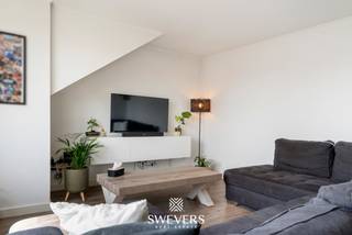 Voor meer info en foto’s, surf naar www.swevers.be – Acaciastraat 71 bus 4 in Hasselt is een gerenoveerd en instapklaar appartement op de vierde verdieping van een verzorgd gebouw uit 1980. Het appartement werd in 2024 vernieuwd en beschikt over een bewoonbare oppervlakte van 74 m². De praktische indeling omvat een inkomhal, een lichtrijke leefruimte met open keuken, twee slaapkamers, een badkamer en meerdere handige bergingen. Dankzij de grote raampartijen geniet de leefruimte van veel natuurlijke lichtinval, wat zorgt voor een aangename en open sfeer. De twee slaapkamers bevinden zich aan de rustige zijde van het appartement en kijken uit op een speelplein. De grootste slaapkamer is 12 m² groot, terwijl de tweede slaapkamer van 9 m² aansluit op een dressingruimte. De centraal gelegen badkamer is vlot bereikbaar vanuit de nachthal. Extra bergruimtes bieden voldoende plaats voor voorraad en huishoudelijke spullen. Bij het appartement hoort bovendien een private carport, ideaal voor de wagen en het stallen van fietsen. Een bijkomend voordeel op deze centrale locatie. De ligging in de Hasseltse deelgemeente Runkst is bijzonder praktisch. Het centrum ligt op slechts 900 meter, terwijl winkels, scholen, restaurants en ontspanning zich op ongeveer 500 meter bevinden. Openbaar vervoer bereikt u op circa 350 meter en de op- en afritten van de snelweg liggen op ongeveer 2 kilometer. Een ideale woonst voor wie comfortabel en centraal wil wonen, met alle dagelijkse voorzieningen op wandelafstand. Voor meer informatie, bel 011 255 155. Bron bewoonbare oppervlakte: EPC – verslag.