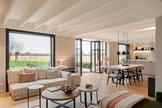 Deze hoogwaardig afgewerkte nieuwbouwwoning, te koop onder het gunstige stelsel van registratierechten, ligt op een uitstekend bereikbare en toch zeer groene locatie in Hansbeke. Het zorgvuldig aangelegde perceel vormt een natuurlijk verlengstuk van de woning en biedt een prachtig, rustgevend panorama over de omliggende natuur.<br /><br />Bij binnenkomst verwelkomt de ruime inkomhal met gastentoilet u en zet meteen de toon voor de rest van het huis. De open leefkeuken met kwaliteitsvolle toestellen vormt het hart van de woning en sluit naadloos aan op de eetplaats en leefruimtes. Dankzij de grote raampartijen, volledig georiënteerd op de tuin, vloeien binnen- en buitenleven harmonieus in elkaar over. De leefruimtes zijn voorzien van vloerverwarming voor optimaal comfort. Aansluitend bevindt zich een praktische wasplaats met extra bergruimte en buitendeur.<br /><br />Op de eerste verdieping vindt u drie volwaardige slaapkamers en twee badkamers. De master bedroom biedt luxe met een eigen dressing en ensuite badkamer. De twee overige slaapkamers delen een tweede, ruime badkamer met ligbad.<br /><br />De hoger gelegen verdieping herbergt een riante, multifunctionele ruimte die kan dienen als extra slaapkamer, kantoor of hobbyruimte.<br /><br />Naast de woning staat een kwalitatief afgewerkte garage, momenteel ingericht als inspirerend thuiskantoor. Deze eigendom staat garant voor een doordachte indeling en uitzonderlijke afwerking.<br /><br />Meer info en 3D-tour op www.hillewaere-vastgoed.be
