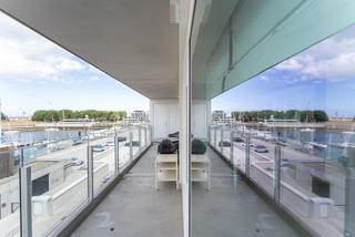 Ontdek dit recente appartement met drie slaapkamers in Zeebrugge, opgeleverd in 2022 en gelegen op een toplocatie met een prachtig uitzicht over de jachthaven. Met een bewoonbare oppervlakte van 133 m², een uitzonderlijk brede gevel en een zonnige oriëntatie geniet je hier van een aangename woonomgeving waar licht, ruimte en comfort perfect samenkomen.

De royale leefruimte baadt in het natuurlijke licht dankzij de brede raampartijen en sluit naadloos aan op het ruime zonneterras. Hier geniet je de hele dag van de zon en van een uniek uitzicht over de jachthaven. De open keuken is afgewerkt met kwalitatieve materialen en vormt samen met de leefruimte het hart van het appartement, ideaal om te ontspannen of gasten te ontvangen.

De doordachte indeling omvat drie volwaardige slaapkamers, waaronder een master bedroom met dressing, en twee stijlvolle badkamers. Daarnaast beschikt het appartement over twee praktische binnenbergingen en twee buitenbergingen, waardoor ook aan opbergruimte geen gebrek is. De slimme indeling en ruime kamers maken dit appartement bijzonder geschikt als gezinswoning of als comfortabele tweede verblijfplaats aan de kust.

Een ruime garagebox wordt mee verkocht aan € 85.000, een absolute meerwaarde op deze gegeerde locatie.

Op zoek naar een recent appartement met drie slaapkamers en zicht op de jachthaven in Zeebrugge? Contacteer Stephanie op 0472 77 86 60 of via stephanie@keyimmo.be