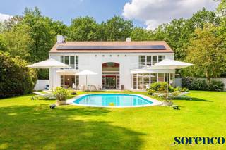 <strong>Op een van de meest prestigieuze locaties Hof ter Linden / Bellemond te Schilde, vindt u deze moderne en lichtrijke architectenvilla op een magnifiek perceel van 2.675m², gebouwd door architect John Bontinck. Gelegen in het groen maar tegelijkertijd centraal nabij de dorpskern, straalt deze villa een vakantiesfeer uit die doet denken aan de Côte d'Azur en de Provence.<br /><br />INDELING:<br /></strong>Bij binnenkomst via de INKOMHAL treft u een apart gastentoilet met handenwasser en een vestiaire. Een dubbele glazen deur biedt toegang tot de riante en lichte WOONKAMER met een majestueus raam dat doorloopt tot de verdieping. De leefruimte, opgesplitst in een zithoek, salon en eetkamer, is voorzien van een eiken parketvloer en een open haard, en biedt een wijds uitzicht op de tuin en het zwembad. U wordt direct gecharmeerd door het vakantiegevoel dat deze villa uitstraalt, waarbij de ruimtes mooi in elkaar vloeien. <br /><br />Aansluitend aan de leefruimte bevindt zich de volledig geïnstalleerde LEEFKEUKEN met een kookeiland, ontbijthoek, tal van opbergkasten en recente moderne toestellen, waaronder een dubbele spoelbak, kookplaat, dampkap, oven, Amerikaanse koelkast en afwasmachine. De keuken wordt overspoeld met natuurlijk licht door de kamerhoge raampartijen en biedt een prachtig uitzicht op de tuin. <br /><br />Tussen de keuken en de garage is een praktische DOUCHEKAMER, ideaal na een verfrissende duik in het zwembad. <br />De inpandige dubbele GARAGE biedt ruimte voor twee wagens en heeft een automatische toegangspoort. Daarnaast is er een ruime oprit met plaats voor meerdere wagens, wat extra gemak en parkeerruimte biedt voor u en uw gasten.<br /><br />Een elegante houten trap leidt naar de <span>eerste verdieping</span>. De overloop op parket geeft toegang tot de verschillende slaapkamers. Dankzij de vide baadt de gang in het licht en biedt het een uitkijkplaats over de magnifieke tuin.<br /><br />De MASTERBEDROOM heeft een ensuite walk-in dressing en ingerichte BADKAMER met ligbad, dubbele lavabo en een toilet. <br />SLAAPKAMER 2 ca. 31,20m² op parket met ingemaakte kasten geeft uit op een prachtig terras en biedt een prachtig uitzicht op de tuin. SLAAPKAMER 3 ca. 20,4m² en SLAAPKAMER 4 ca. 18,60m² delen de tweede BADKAMER met ligbad, lavabo en een toilet. <br />Verder is er nog een BERGING van ca. 3m², waar een extra douchekamer of wasplaats mogelijk is.<br /><br />Geniet volop van de zonnige tuin in privacy met een aangelegd terras, verwarmd zwembad en een tuinhuis. Deze buitenruimte biedt de perfecte setting voor ontspanning, zomerse barbecues en gezellige avonden. Beleef het ultieme vakantiegevoel zonder uw huis te verlaten. <br />
<p>Deze villa is een waar paradijs voor wie houdt van een luxe levensstijl met een vleugje vakantie. De ruime indeling en grote ramen zorgen voor een lichte en luchtige sfeer. <br /><br /></p>
<strong>BIJZONDERHEDEN:<br /></strong>* <span>Lichtrijke moderne architectenvilla gelegen in een prestigieuze villawijk te ‘s Gravenwezel.<br /></span>* Gebouwd door architect John Bontinck<br />* Conforme keuring (2025), 15 zonnepanelen (2024) , EPC: 164kWh/m², regenwaterput, vloerverwarming op het gelijkvloers, gevel geschilderd 2023, Bouwjaar 2000, asbestvrij.<br />* Parketvloeren, Bose-installatie<br />* Inpandige garage, oprit voor meerdere wagens, zolderberging, kelder <strong><br /></strong>