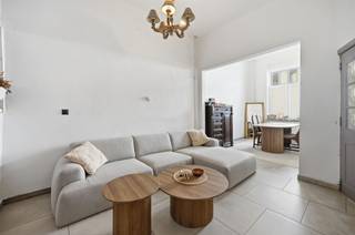 De statige voorgevel van deze hoge woning met dito plafonds, werd voorzien van een mooie plint in blauwe hardsteen en witte sierpleister, die...