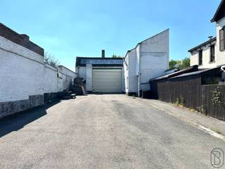 Groot MAGAZIJN van 400m2 met voorliggende grote PARKING en oprit, burelen en tuin. Gelegen in WOONGEBIED. Drijfkracht en regenwater aanwezig...