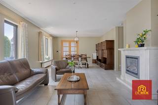 Deze piekfijn onderhouden viergevel woning is gelegen op een centrale locatie en geniet van enorm veel ruimte. Het huis werd geboouw in 2000 met kwaliteitsvolle materialen. Dankzij de doordachte indeling is deze woning geschikt voor grote gezinnen, maar ook de combinatie wonen en werken is perfect mogelijk.Via de oprit, waar meerdere wagens kunnen geparkeerd worden bereikt u de voordeur en verder de garage. Eenmaal binnen in de woning vindt u op het gelijkvloers de ruime, lichtrijke woonkamer met ensuite veranda waar u een prachtig zicht op de aangelegde tuin. Verder is er op de begane grond de ingerichte keuken, berging, apart toilet en een eerste slaapkamer met ensuite badkamer. Uitsluitend wonen op het gelijkvloers is dus perfect mogelijk. Op de eerste verdieping zijn er nog 3 slaapkamers, een hobbyruimte, een tweede badkamer en nog een berging. Via een luik bereikt u de geïsoleerde zolder. Het huis werd ook voorzien van een ruime droge kelder. Achetraan is de woning bereikbaar via de Vogelenzangstraat, dit maakt dat tuin eigenlijk nog zou kunnen afgesplitst worden als bouwgrond. Verder is de tuin één van de mooiste troeven van deze woning, hij werd aangelegd met veel oog voor detail en verkeert in topconditie.Energetisch staat deze woning ook op punt. De verwarming gebeurt via en condenserende gasketel, er zijn zonnepanelen aanwezig en er is overal dubbel glas. Buitenmuren en dak zijn perfect geïsoleerd. Toiletten kunnen op regenwater aangesloten worden.