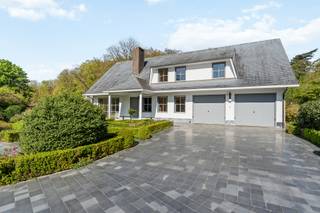 Charmante villa met ruime uitbreidingsmogelijkheden op een uniek privé-domein grenzend aan natuurgebied te Schilde<br /><br />In één van de meest gegeerde en residentiële buurten van Schilde, discreet gelegen aan het einde van een doodlopende straat, bevindt zich deze karaktervolle villa op een perceel van 4968m². Een locatie waar rust, privacy, natuurbeleving en comfort naadloos samenkomen.<br /><br />Indeling gelijkvloers:<br />De villa verwelkomt u via een ruime en lichtrijke inkomhal met vestiaire en gastentoilet. Vanuit hier bereikt u de aangename leefruimte met open haard en grote raampartijen, die zorgen voor een prachtig uitzicht op de fraai aangelegde tuin. Aansluitend bevindt zich een sfeervolle leefveranda, volledig omringd door schuiframen en voorzien van automatische zonnescreens, zodat u het hele jaar door geniet van een maximale lichtinval en een harmonieus zicht op het groen.<br /><br />De volledig uitgeruste keuken biedt eveneens zicht op en directe toegang tot het terras en wordt vergezeld door een praktische berging. Aansluitend bevindt zich een tweede gezellige leef- en eetruimte, voorzien van een houtkachel, wat deze ruimte bijzonder warm en uitnodigend maakt. Tevens is er een aparte bureauruimte, ideaal voor wie praktijk- of kantooractiviteiten aan huis wenst. De inpandige garage met automatische poort biedt plaats aan twee voertuigen.<br /><br />Eerste verdieping:<br />De nachthal leidt naar de master bedroom met ensuite badkamer, aangevuld met drie comfortabele, volwaardige slaapkamers. Daarnaast is er een tweede badkamer met douche en een bijzonder ruime, functionele wasplaats.<br /><br />Tuin en buitenbeleving:<br />De zuidwest-georiënteerde tuin vormt een ware oase van rust, met weidse vergezichten en een bijzonder harmonieuze groenbeleving. De tuin werd smaakvol aangelegd.<br /><br />Bijzonderheden:<br />- Maximale privacy, prestigieuze ligging & ideale zonoriëntatie<br />- Renovaties: 1997 (aanbouw leefruimte) – 1999 (gedeeltelijk buitenschrijnwerk)<br />- Verwarming op aardgas (Viessmann) via radiatoren en convectoren<br />- Dubbele beglazing (hout & aluminium)<br />- Rolluiken aanwezig<br />- Videofonie & automatische toegangspoort<br />- Oprit met plaats voor ca. 6 wagens<br />- Bergzolder toegankelijk via vlizotrap