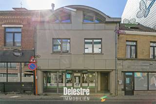 Deze kwalitatief verhuurde investeringseigendom is uitstekend gelegen in het hart van Asse, in de Nieuwstraat. Dankzij de centrale ligging geniet het pand van veel passage, een uitstekende zichtbaarheid en parking voor de deur. Het commerciële gelijkvloers is momenteel verhuurd aan het gekende GLOWI (Poetsbureau) via een handelshuurovereenkomst die gestart is op 1 augustus 2017 en recent werd hernieuwd vanaf 1 augustus 2026. De actuele maandelijkse huurprijs bedraagt € 1.668,84, aangevuld met € 50 vaste kosten per maand. Het handelsgelijkvloers beschikt over een oppervlakte van circa 170 m² en is bovendien voorzien van een ruime kelder van circa 98 m². De ligging is bijzonder commercieel interessant, met onder andere Leonidas, AZORG en Konvert Interim in de onmiddellijke omgeving. Het pand beschikt over een EPC-label C en de elektrische installatie is conform. Daarnaast werd het dak extra geïsoleerd, werd de oude ventilatie-unit verwijderd en zijn alle voorzieningen aanwezig om zonnepanelen te plaatsen. Het pand is bovendien asbestveilig. Een interessante opportuniteit voor investeerders die op zoek zijn naar een goed gelegen, verhuurde commerciële eigendom met een stabiele huurstroom in het centrum van Asse. Interesse of wenst u meer informatie of een bezoek ter plaatse? Contacteer ons via info@immodelestre.be of 054 33 62 52. Meer informatie vindt u op www.immodelestre.be.