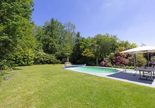 <p><span>In een van de meest exclusieve straten van Hasselt bevindt zich deze karaktervolle villa uit 1975, gelegen op een perceel van maar liefst ±24are42. De woning onderscheidt zich door haar moderne architectuur en uitzonderlijk potentieel. Ideaal voor wie op zoek is naar een stijlvolle renovatie op een toplocatie! </span></p><p><span> </span></p><p><span>Bij het betreden van de woning komt u terecht in een ruime inkomhal met vestiaire en gastentoilet. Aansluitend bevindt zich een afzonderlijke bureauruimte, ideaal voor thuiswerk of een vrij beroep. De leefruimte werd ontworpen met oog voor sfeer en omvat een zithoek, een gezellige zitkuil met houthaard, een eetplaats en een ruime leefkeuken. Verder biedt de lichtrijke tuinkamer een aangenaam contact met de tuin en het omliggende groen.</span></p><p><span> </span></p><p><span>Op het gelijkvloers bevinden zich daarnaast een praktische zij-ingang, een polyvalente ruimte die perfect kan dienen als hobbyruimte of koele berging, evenals twee inpandige garages waarvan één momenteel ingericht werd als wasplaats.</span></p><p><span> </span></p><p><span>De verdieping beschikt over een ruime, lichtrijke overloop die toegang geeft tot vier volwaardige slaapkamers, waarvan twee voorzien zijn van een wastafel. Twee slaapkamers hebben bovendien toegang tot een privéterras. De badkamer is uitgerust met een ligbad, douche, bidet en dubbele wastafel. Verder is er een apart toilet en een praktische linnenkast.</span></p><p><span> </span></p><p><span>Ook de kelderverdieping biedt bijzonder veel ruimte en functionaliteit met onder meer een wijnkelder, voorraadkelder, bergingen en technische ruimtes.</span></p><p><span> </span></p><p><span>De volwassen tuin met volgroeide bomen vormt een oase van rust en biedt een prachtig zicht. Privacy gegarandeerd! Verder is er een verwarmd zwembad op warmtepomp. </span></p><p><span> </span></p><p><span>Een unieke eigendom voor wie op zoek is naar ruimte, privacy en architecturale charme op een absolute toplocatie in Hasselt.</span></p><p><span> </span></p><p><span>Extra’s: volledig vergund, afzelia houten ramen met dubbele beglazing, zonnescreens, gescheiden riolering, kruipkelder, ...</span></p><p><span>Breedte perceel op bouwlijn: ±24m</span></p><p><span> </span></p>