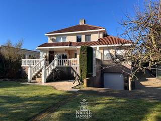 Deze gezinswoning in mediterrane stijl is verrassend ruim ingedeeld en geniet van enorm veel lichtinval. Momenteel is de woning ingericht met een apart appartement met twee slaapkamers op de verdieping maar dit kan ook gewoon de etage met badkamer en slaapkamers zijn van de hoofdwoning. Er is een inpandige garage en het huis is volledig onderkelderd. <br /><br />Het huis ligt aan de stadsrand van het centrum op een vlot bereikbare locatie tov scholen, sport, winkels,... De mooie markt van Maaseik bereik je in enkele minuten wandelen maar ook het schilderachtige Aldeneik met de Maasplassen ligt in je achtertuin. Op het grote terras of in de lager gelegen tuin is het ook heerlijk vertoeven van privacy en groen op eigen terrein. <br /><br />=> Gelijkvloers<br />- Op het gelijkvloers is momenteel een centrale hal met trap naar het bovengelegen appartement dat perfect als bovenverdieping van een woning gebruikt kan worden<br />- Verder is er een extra inkomhal met ruimte voor vestiaire<br />- Ook is deze hal voorzien van een volledig betegeld gastentoilet met fonteintje<br />- Lichtrijke woonkamer met inbouwhaard<br />- Toegang naar het groot betegeld terras via het schuifraam<br />- Aansluitend ligt de verzorgde keuken met granieten werkblad<br />- De keuken is voorzien van alle comfort<br />- Rechtstreeks toegang tot de praktische bijkeuken met extra aanrecht met uitgietbak en aansluiting voor wasmachine<br />- Grote slaapkamer met laminaatvloer en vaste kastenwand<br />- Volledig betegelde badkamer met ligbad, douche, toilet en wastafel in fraai badkamermeubel <br />- Tweede slaapkamer/bureel op het gelijkvloers<br />- Ruime inpandige garage met tegelvloer en automatische sectionaalpoort<br />- Fantastisch ruim betegeld en deels overdekt terras<br /><br />=> Verdieping<br />- Deze verdieping is momenteel ingericht met een aparte woongelegenheid maar dit kan perfect gebruikt worden als eerste etage van de gelijkvloerse woning<br />- Leefruimte met ingerichte keukenblok <br />- Betegelde badkamer met ligbad en wastafel en aansluiting voor wasmachine<br />- Momenteel zijn er twee slaapkamers op de verdieping maar de leefruimte kan ook nog omgevormd worden tot meerdere kamers<br />- Gezellig terrasje aan de achterzijde<br /><br />=> Tuin<br />- Zicht op de lager gelegen tuin vanop het mooie terras<br />- Voldoende privacy en rechtstreekse toegang naar de inpandige garage<br />- Ruim, zonnig betegeld terras toegankelijk vanuit de woonkamer<br /><br />=> Indeling<br />- Gelijkvloers: gemeenschappelijke inkomhal, private inkomhal met vestiaire, gastentoilet, woonkamer, keuken, bijkeuken/wasplaats, ouderlijke slaapkamer, badkamer, logeerkamer/bureel, inpandige garage;<br />- Verdieping (momenteel tweede woongelegenheid) : inkomhal met vestiaire, leefruimte met keukenblok (kunnen extra slaapkamers zijn), badkamer, bergruimte, twee slaapkamers, terrasje <br />- Kelder: volledig onderkelderd met veel opbergruimte en extra badkamer;<br />- Zolder: opbergzolder.