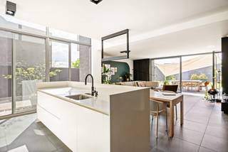 Eigentijdse architectuur ontmoet ultieme flexibiliteit in Retie.<br />Licht, ruimte en topkwaliteit komen samen in deze moderne gezinswoning met een multifunctioneel bijgebouw. Dankzij het hoogwaardige maatwerk en de geavanceerde technieken is deze eigendom volledig klaar voor de toekomst.<br /><br />Indeling:<br />Gelijkvloers: Licht, design en naadloos comfort. De lichte leefruimte valt direct op door de hoge raampartijen en een volledig openende achtergevel. Het interieur ademt luxe met verfijnd maatwerk, waaronder een thuisbureau, bibliotheek en tv-meubel. <br />De open leefkeuken vormt het hart van de woning en is voorzien van een kookeiland, composiet werkblad, Quooker en Miele-apparatuur. De keramische tegelvloer loopt drempelloos door naar het terras.<br />Verdiepingen: Luxe slaapcomfort en zelfstandige studio<br />De eerste verdieping biedt twee slaapkamers en een luxe badkamer met elegant maatwerk. <br />De tweede verdieping beschikt over extra slaapkamers, een studioruimte en eigen sanitair. Deze etage leent zich perfect als zelfstandige studio voor inwonende familie, een tienerflat of een rustig thuiskantoor.<br /><br />Duurzaamheid in optima forma (Energielabel A). De woning blinkt uit in energiezuinigheid en is uitgerust met: Geothermische warmtepomp met vloerwarming én vloerkoeling. Zonnepanelen en een slimme laadpaal op de oprit. <br />Multifunctioneel bijgebouw<br />Achteraan het perceel ligt het vrijstaand bijgebouw. Het biedt maximale privacy en is het ideaal als zorgwoning, gastenverblijf, praktijkruimte of kantoor aan huis.<br /><br /><br />De onderhoudsarme tuin beschikt over sfeerverlichting, een zonneluifel en een gezellige bar. <br />De prachtige moderne woning ligt in een rustige, groene omgeving in Retie met een uitstekende bereikbaarheid: winkels en het centrum liggen op wandelafstand (ca. 700m - 1km) en de snelweg E34 richting Antwerpen en Eindhoven bevindt zich op slechts 2,3 kilometer.<br /><br />Belangrijkste troeven:<br />-Instapklaar<br />-Hoogwaardige maatwerkafwerking in de gehele woning<br />-Flexibel: Uitstekend geschikt voor wonen, werken of zorg aan huis<br />-Toekomstgericht: Energielabel A dankzij geothermie en zonnepanelen