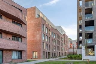 Dit nieuwbouwappartement met 3 slaapkamers is gelegen in het centrum van Leuven in een de prachtige ontwikkelijk 'burenberg'.<br />De verkoop geschiedt onder btw stelsel. <br /><br />We betreden het appartement via de inkomhal met apart gastentoilet. Vanuit de inkomhal hebben we toegang tot de lichtrijke woonkamer en de open en volledig geïnstalleerde keuken, die toegang biedt tot het terras met uitstekend uitzicht over de stad. Naast de keuken vinden we een praktische berging met aansluiting voor wasmachine en droogkast. <br /><br />Verder vinden we 3 slaapkamers van 13,5m², 12m² en 9m². Het appartement beschikt ook over 2 badkamers, waarvan 1 met douche, dubbel lavabo en toilet en de andere badkamer met douche en enkel lavabo.<br /><br />Tot slot heeft dit appartement 2 ondergrondse autostaanplaatsen en een private kelderberging.<br />De ondergrondse autostaanplaatsen kunnen optioneel bij aangekocht worden voor 40.000 euro per staanplaats.<br />De prijs voor het appartement en staanplaatsen is exclusief btw.<br /><br />Elektriciteit is conform. Het EPB is nog in opmaak zal zeker A zijn. Verwarming is met geothermie, vloerverwarming. Tot slot zijn er nog zonnescreens en een fietsenstalling.<br /><br />Bij verdere vragen of interesse kan u ons steeds contacteren!