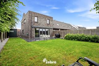 <strong>Het bezoekmoment gaat door op zaterdag 5 september 2026 (enkel op afspraak).</strong><br /><br />De woning (BJ 2015) combineert hedendaags wooncomfort met uitstekende energieprestaties dankzij vloerverwarming, een warmtepomp en zonnepanelen (11 stuks, 4785 Wp), goed voor een uitzonderlijk energiezuinig EPC-label A+. Verder beschikt de woning over diverse extra voorzieningen, waaronder domotica, een ventilatiesysteem D, een waterverzachter en een regenwaterput van 15.000 liter.<br /><br />Via de inkomhal met gastentoilet betreedt u de woning. De lichtrijke leefruimte met volledig uitgeruste open keuken vormt het hart van de woning.<br />De keuken werd afgewerkt met kwalitatieve materialen en is uitgerust met moderne toestellen, waaronder een inductiekookplaat met geïntegreerde afzuiging, twee combi-ovens, ... Aansluitend bevindt zich een praktische keukenberging.<br /><br />Op de eerste verdieping zijn er vier volwaardige slaapkamers (plat dak), allemaal voorzien van internet- en tv-aansluitingen. De ruime badkamer beschikt over een dubbele wastafel, ligbad en douche. Daarnaast is er een afzonderlijk toilet aanwezig.<br /><br />De zonnige, zuidwestgerichte tuin biedt een aangename buitenruimte en beschikt over een praktische uitweg naar de bijhorende garagebox, inbegrepen in de prijs. Verder zijn er een zonneluifel en een tuinhuis aanwezig. Via het poortje aan de rechterzijde van de woning is de tuin bovendien gemakkelijk bereikbaar.<br /><br /><strong>Ook wild geworden van deze thuis?<br />Twijfel niet langer en leg vandaag nog uw bezoek vast!</strong>