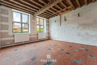 Voor meer info en foto’s, surf naar www.swevers.be – Begijnhof 20 in Sint-Truiden is een volledig gerenoveerde, instapklare woning waar authentieke elementen en hedendaags wooncomfort mooi samenkomen. Hoge plafonds, originele details en het karaktervolle houten gebinte geven de woning een bijzondere uitstraling. Op het gelijkvloers bevinden zich een inkomhal, een zitruimte van 21,5 m² en een ruime keuken van 18,9 m² met plaats voor een grote eettafel. Achteraan sluiten een berging, terras en gemeenschappelijke tuin rechtstreeks aan op de woning. De eerste verdieping telt twee ruime slaapkamers en een centraal gelegen badkamer. Op de tweede verdieping bevinden zich nog twee kamers van 16 m² en 18 m², aangevuld met een speelzolder van 14 m². Deze ruimte kan ook dienstdoen als hobby-, werk- of ontspanningsruimte. Verder beschikt de woning over een kelder van 14,7 m², een wasplaats van 6,6 m² en een fietsenstalling. Het perceel heeft een oppervlakte van 1a 46ca. Dankzij het terras en de gemeenschappelijke tuin geniet je ook in deze centrale omgeving van aangename buitenruimte. De ligging is bijzonder praktisch: winkels en ontspanning liggen op ca. 250 meter, horeca op 200 meter, sportvoorzieningen op 300 meter en een bushalte op slechts 95 meter. Het station bevindt zich op 1,2 km, scholen op 780 meter en kinderopvang op 500 meter. Voor meer informatie, bel 012 699 900. Bron bewoonbare oppervlakte: EPC – verslag.
