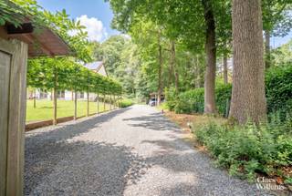In het gegeerde Bois du Strihoux in Rebecq bevindt zich deze verzorgde villa op een perceel van 12 are 36 centiare. De ligging is bijzonder: het Bois du Strihoux maakt deel uit van het historische boscomplex Bos Ter Rijst – Bois du Strihoux, dat ooit ongeveer 360 hectare omvatte. Vandaag vormt deze groene residentiële omgeving een van de meest gewaardeerde woonzones van Waals-Brabant, met brede dreven, grote percelen, privacy en een rustige sfeer. Hier woont u midden in het groen, terwijl Halle, Tubeke, Edingen en Brussel vlot bereikbaar blijven.
Via de automatische toegangspoort bereikt u het afgesloten perceel. De tuin met volwassen bomen biedt zithoeken waar u in alle rust geniet van de groene omgeving. De verwarmde dual-zone swimspa met tegenstroominstallatie en de ruime jacuzzi vormen samen een exclusieve privéwellness. Dankzij de doordachte verwarmingsinstallatie blijven de gebruikskosten beperkt: het zwemgedeelte benut de energie van de zonnepanelen, terwijl het jacuzzigedeelte via een warmtewisselaar op de centrale verwarming wordt verwarmd.
Op het gelijkvloers bevinden zich de leefruimte met open haard, de eetplaats en de open keuken. Dankzij de schuifdeur kan het afzonderlijke salon worden afgesloten en ingericht als bureau, leeskamer of extra zithoek.
De eerste verdieping omvat drie ruime slaapkamers. Twee slaapkamers worden verbonden door een tussenliggende badkamer. Daarnaast is er een afzonderlijke douchekamer met toilet.
Ook de kelderverdieping biedt veel mogelijkheden. Hier bevindt zich een ruime homecinema of tv-zaal met grote raampartij en daglicht. De ruimte is voorbereid voor 5.1 surroundgeluid. Verder beschikt deze verdieping over een extra douchekamer en een ruimte voor hobby, fitness, speelkamer of praktijkruimte.
Met een bruto vloeroppervlakte van 276 m² combineert deze villa ruimte, comfort en energiezuinigheid. De 27 zonnepanelen van samen 11,1 kWp, de regenwaterput van 10.000 liter, het bekabelde datanetwerk met wifi-access points, de voorbereiding voor een 22 kW-laadpaal, vernieuwde sanitaire leidingen, de grotendeels vernieuwde elektrische installatie en energiezuinige radiatoren maken deze woning klaar voor de toekomst.
De ligging in het Bois du Strihoux, de verwarmde swimspa, de jacuzzi, de ruime leefruimtes, de technische uitrusting en het groene perceel maken van deze villa te koop in Rebecq een zeldzame opportuniteit voor wie rust, privacy, natuur, wellness en modern wooncomfort wil combineren.
