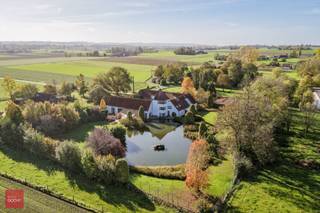 Gelegen op de grens met Wannegem-Lede, prachtig gerestaureerde vierkantshoeve op ca. 1,3ha bestaande uit inkomhal, living met open ingerichte...