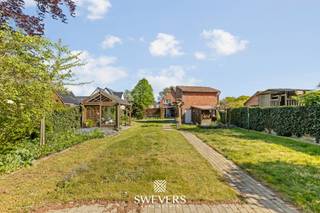 Voor meer info en foto’s, surf naar www.swevers.be – Deze halfopen woning in de Onze-Lieve-Vrouwstraat 69 in Heusden-Zolder biedt veel ruimte, licht en potentieel op een mooi groen perceel van 1.680 m². De woning dateert van 1953, werd steeds goed onderhouden en beschikt over een bewoonbare oppervlakte van 192m². Binnenkomen doet u via de inkomhal met trap. U betreed vervolgens de eerste ruime leefruimte, gevolgd door de centraal gelegen keuken van 12 m² , die vernieuwd werd in de jaren 2000. Deze sluit dan weer aan op een tweede leefruimte die perfect dienst kan doen als veranda of ontbijthoek en dankzij de grote raampartij geniet van veel licht en een mooi zicht op de tuin. Achteraan bevinden zich de vernieuwde badkamer met inloopdouche en een aparte wasplaats/berging. Op de eerste verdieping zijn er drie ruime slaapkamers van 16 m², 18 m² en 16 m². Eén kamer is ingericht als kleine studio met slaapruimte, dressing, compacte kitchenette en leefhoek. Verder is er nog een apart toilet. Via een vaste trap bereikt u de zolder van ca. 40 m², die tal van mogelijkheden biedt voor extra kamers of hobbyruimte. Ook is er een kelder van 7 m² en een vrijstaand bijgebouw. De tuin is een grote troef, met achteraan veel ruimte voor een moestuin, dieren of ontspanning in alle privacy. Winkels, scholen en ontspanning liggen dichtbij, openbaar vervoer op 200 meter en de snelweg op 1 km. Voor meer informatie, bel 011 255 155. Bron bewoonbare oppervlakte: EPC – verslag.