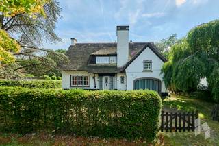 Ruime karakervolle woning met 5 slaapkamers op een mooi perceel van 837 m²<br /><br />Deze stijlvolle woning is zeer lichtrijk en straalt volop karakter uit door de mooie authentieke materialen die er zijn. <br />Gunstige ligging vlakbij het centrum en de invalswegen.<br />De grote inpandige garage zou eventueel kunnen omgebouwd worden naar een praktijkruimte of gelijkvloerse slaapkamer.<br />De zonnige ZW-tuin biedt volop privacy en heeft als extra troef dat er achteraan een toegang is via de Beukenhoflaan. Bovendien heb je zicht op het mooie bos aan de achterkant.<br /><br /><strong>INDELING:</strong><br /><strong>Gelijkvloers:</strong> Inkomhal met vestiaire en toilet, leefruimte met haard, keuken met eethoek, dubbele garage en ruime kelder.<br /><strong>Verdieping:</strong> Overloop , toilet, badkamer en 4 tot 5 slaapkamers, ruime zolder bereikbaar via luik.<br /><br /><strong>BIJZONDERHEDEN:</strong><br />- GEEN renovatieplicht;<br />- elektra conform;<br />- spouwmuurisolatie 2020;<br />- nieuwe boiler 2019.