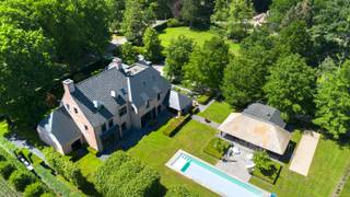 Magnifique villa de haut standing sur un terrain de 8 042 m² située dans l'avenue la plus unique et recherchée du résidentiel d'Oud-Turnhout. La villa a une surface habitable de 1 253 m² et a vraiment tout : 7 chambres, 6 salles de bains, des espaces de vie spacieux, un bureau, 2 garages intégrés, un sous-sol entièrement aménagé avec accès séparé, un jardin magnifiquement aménagé avec un luxueux poolhouse équipé de installations de bien-être et une piscine extérieure. Un choix d'aménagement extraordinaire qui dépasse toutes les attentes.<br /><br />Vraiment un chef-d'œuvre de luxe et d'intimité, où l'élégance, la technologie et le confort se rejoignent dans une villa d'une classe inégalée !<br /><br />Rez-de-chaussée :<br />En entrant dans le hall d'entrée de cette villa, vous ressentez immédiatement l'espace et l'ouverture qu'elle offre. Les grandes baies vitrées offrent une lumière magnifique, tout comme les hauts plafonds qui donnent une sensation d'espace. À gauche du hall d'entrée se trouvent des toilettes d'invités et un vestiaire. Les espaces de vie s'étendent sur toute la largeur de la villa. À droite, vous trouverez deux vastes salons en parquet, dont l'un est équipé d'une cheminée au gaz, l'endroit idéal pour recevoir vos invités avec style. Dans l'autre salon, vous pourrez regarder la télévision confortablement. Le plafond atteint la hauteur du faîte et est éclairé par un magnifique lustre. À gauche de la villa se trouve la grande cuisine avec coin repas équipé d'une cheminée au gaz. Les grandes baies vitrées à l'arrière créent une belle connexion avec le jardin et la piscine. La cuisine est un paradis culinaire équipé d'appareils haut de gamme Gaggenau (dont 2 cuiseurs vapeur, 2 fours à chaleur tournante, 2 tiroirs chauffants, plaque à induction, système d'aspiration Bora, 2 grands réfrigérateurs, ...). C'est un régal de prendre l'apéritif ou le petit-déjeuner sur l'îlot de cuisine ou les bancs confortables dans l'alcôve. La terrasse couverte avec éléments chauffants est directement accessible depuis la cuisine. À l'avant de la villa, vous trouverez la partie pratique avec notamment un grand cellier avec chambre froide, friteuse avec hotte, machine à glaçons et de nombreux placards encastrés, un deuxième vestiaire pour manteaux et chaussures attenant à l'entrée arrière et au double garage intégré. Un espace bureau pratique, une salle de jeux pour enfants ou un deuxième coin télé se trouve également à l'avant de la villa et peut être facilement fermé avec une paroi coulissante en verre.<br /><br />Premier étage :<br />L'escalier large recouvert de parquet vous mène à l'étage supérieur. Une porte de sécurité dissimulée avec verrouillage par empreinte digitale sécurise l'étage supérieur. La suite principale se trouve du côté droit et dispose d'un dressing spacieux (Poliform) au centre, d'une salle de bains de luxe avec une double douche à l'italienne, une baignoire îlot en Corean, deux lavabos dans un meuble moderne, équipée de robinetterie Dornbracht, la chambre principale se trouve à l'arrière et offre une belle vue sur le jardin. Cette suite offre également un coin salon/bureau séparé avec cheminée au gaz. De l'autre côté de cet étage, vous trouverez deux chambres d'enfants très spacieuses (30 m² - 55 m²), une salle de bains de luxe avec baignoire, douche et deux lavabos dans un meuble, des toilettes séparées sur le palier et une grande buanderie/buanderie avec de la place pour 4 machines à laver/sécher et de nombreux placards encastrés.<br /><br />Deuxième étage :<br />À cet étage, un palier qui sert également de coin détente/coin