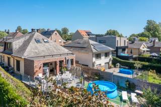 <p>Uitzonderlijk ruime woning van 330m² met terras, garage en bosgrens in residentiële omgeving.</p><p> </p><p>Deze in 1969 gebouwde en nadien aanzienlijk uitgebreide woning biedt een totale oppervlakte van circa 330m² op een rustige locatie, vlot bereikbaar via diverse invalswegen en de R0.</p><p> </p><p>De inkomhal leidt naar de zeer grote leefruimte met salon, eetplaats en bureauhoek, aansluitend op de geïnstalleerde keuken. Zowel leefruimte als keuken genieten zicht op het prachtige terras met zuidoriëntatie en aangrenzend bos.</p><p> </p><p>Op het gelijkvloers bevinden zich twee ruime slaapkamers en een douchekamer. De eerste verdieping voorziet twee bijkomende slaapkamers, een bergkamer en een tweede badkamer.</p><p> </p><p>Verdieping -1, gelegen op tuinniveau, omvat een grote polyvalente ruimte die op heden ingericht is als master bedroom, maar evenzeer geschikt is als bureau, praktijkruimte of hobbyruimte, aangevuld met een douchehoek en sauna.</p><p>Meerdere kelders en een zeer grote garage vervolledigen dit niveau.</p><p> </p><p>De woning geniet een gunstig EPC label C en combineert uitzonderlijke ruimte met een uitstekende bereikbaarheid en een groene, residentiële omgeving.</p>