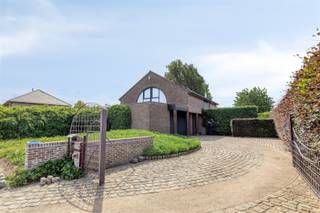 Tijdloze villa met prachtige tuin en adembenemende verzichten. Deze woning werd gebouwd in 1985 door de huidige eigenaar en steeds perfect onderhouden. Indeling: ruime inkomhal met gastentoilet, droge kelder, een zonnige living met afsluitbare zithoek, volledig ingerichte keuken met aansluitend een gezellige orangerie en een berging/wasplaats die is voorzien van ingemaakte kasten. Via de berging heb je toegang tot de ruime garage voor 2 wagens. Op de verdieping bevinden zich 3 ruime slaapkamers, een berging en een badkamer die is uitgerust met een dubbele lavabo, douche, ligbad en extra toilet. Eén van de slaapkamers en de badkamer hebben toegang tot het grote dakterras. Mooi aangelegde, zuid-west geörienteerde tuin met een groot terras, 2 grote vijvers en een ruim tuinhuis. Het epc vermeld in de publiciteit is de score nadat er een investering van € 10.000 (volgens offerte) wordt gedaan om de elektrische verwarming aan te passen naar een warmtepomp systeem.