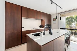 Op een uitstekende ligging, op een boogscheut van het bruisende centrum van Middelkerke, bevindt zich deze exclusieve residentie van amper vijf luxueuze appartementen. Een kleinschalig nieuwbouwproject uit 2025 waar rust, comfort, energiezuinigheid en een hoogwaardige afwerking centraal staan. We bieden u vandaag de unieke mogelijkheid om één van deze exclusieve appartementen te verwerven. <br /><br />De ligging is bijzonder aangenaam: op amper 100 meter van het Normandpark geniet je van een groene omgeving en rustige wandelingen, terwijl het strand, het nieuwe casino, gezellige horeca en winkels op slechts een tiental minuten wandelen bereikbaar zijn. Ook het openbaar vervoer bevindt zich vlakbij.<br /><br />Het appartement zelf biedt maar liefst 124 m² aan hoogwaardig wooncomfort, verdeeld over twee volwaardige verdiepingen. De leefruimtes werden ontworpen met oog voor licht, ruimte en beleving.<br /><br />Vooraan bevindt zich de indrukwekkende leefkeuken, een echte eyecatcher van het appartement. De keuken is uitgerust met een groot kookeiland en afgewerkt met witte natuursteen en elegante zwarte accenten. Een heerlijke plek om uitgebreid te koken, vrienden te ontvangen of gezellig samen te genieten. Vanuit de keuken stap je rechtstreeks het eerste terras van 10 m² op, waar je geniet van een aangenaam en open uitzicht.<br /><br />Aan de andere zijde van de leefruimte bevinden zich de stijlvolle zithoek en een praktische bureauruimte. Hier geniet je van een aangenaam terras van 5 m², perfect georiënteerd om in alle rust van de avondzon te genieten. Verder is er op deze verdieping nog een handige bergruimte en een afzonderlijk toilet.<br /><br />De bovenverdieping biedt plaats aan drie volwaardige slaapkamers. De master bedroom beschikt bovendien over een eigen dressing en biedt een aangename, rustige slaapomgeving. De moderne badkamer vormt een stijlvolle aanvulling op het geheel en is uitgerust met een prachtige inloopdouche.<br /><br />Ook technisch is dit appartement volledig mee met zijn tijd. De residentie wordt voorzien van warmtepompen, vloerverwarming, zonnepanelen en ventilatie type D. In combinatie met de kwalitatieve en duurzame materialen staat dit garant voor een bijzonder comfortabel, energiezuinig en toekomstgericht woonconcept.<br /><br />Voor wie extra comfort wenst, bestaat de mogelijkheid om een carport met berging aan te kopen voor € 35.000.<br /><br />Een uitzonderlijk appartement voor wie op zoek is naar ruimte, luxe, energiezuinigheid en een uitstekende ligging aan de Belgische kust. De verkoop gebeurt onder het btw-stelsel. De plannen zijn beschikbaar en kunnen via onze website worden geraadpleegd.<br /><br />De aanwezige meubelen kunnen eventueel mee worden overgenomen.<br /><br />Een unieke kans om te wonen in een kleinschalige en exclusieve residentie, vlak bij alles wat Middelkerke te bieden heeft.