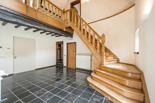 Verscholen in het groen van de gegeerde Bellevuedreef bevindt zich deze karaktervolle klassieke villa op een indrukwekkend parkdomein van ca. 1,4 hectare. Een eigendom waar ruimte, privacy en een bijzonder aangename woonbeleving samenkomen, omgeven door een volgroeide en zorgvuldig aangelegde tuin.<br /><br />De villa beschikt over ca. 575 m² bewoonbare oppervlakte en wordt aangevuld met een volwaardig gastenverblijf in het poolhouse, een afzonderlijke conciërgewoning, een inpandige garage voor drie wagens en een verwarmd buitenzwembad. De omvang van het domein, de volwassen begroeiing en de verschillende woon- en verblijfsfuncties maken van deze eigendom een bijzonder compleet geheel op een van de meest residentiële locaties van Schilde.<br /><br />Indeling gelijkvloers:<br />De centrale inkomhal met vestiaire en gastentoilet vormt het vertrekpunt van de woning en geeft toegang tot de verschillende leefruimtes.<br />De royale leefruimte omvat een zitkamer en eetkamer, aansluitend op een afzonderlijke studeerkamer. Daarnaast bevindt zich een ruim bureel met maatwerkkasten, waardoor ook professioneel of rustig thuiswerken perfect in de woning kan worden geïntegreerd.<br />Centraal in het dagelijkse leven staat de ruime leefkeuken, opgebouwd rond een gezellige ontbijtruimte met grote schuiframen naar het terras en de tuin. Het keukengedeelte met eiland is uitgerust met diverse inbouwtoestellen. Een praktische berging zorgt voor een tweede verbinding met de eetkamer, terwijl de bijkeuken met afzonderlijke zij-ingang bijkomende functionaliteit biedt.<br /><br />Eerste verdieping:<br />De nachthal leidt naar vier ruime slaapkamers, die elk over een eigen badkamer beschikken.<br />De mastersuite vormt een royaal privégedeelte met slaapkamer, dressing en badkamer. Daarnaast bevinden zich op deze verdieping een tweede ruime slaapkamer, een gastenkamer en een kinderkamer, telkens met een eigen badkamer.<br /><br />Vanuit de mastersuite is er via een tussengang en diensttrap verbinding met het gedeelte boven de garage.<br /><br />Conciërgewoning:<br />Boven de inpandige garage bevindt zich een afzonderlijk verblijfs- en conciërgegedeelte, bestaande uit een polyvalente leefruimte, slaapkamer en badkamer. Dit gedeelte leent zich uitstekend voor inwonend personeel, een au pair, familie of gasten.<br /><br />Kelder:<br />Via een natuurstenen trap is de kelderverdieping bereikbaar. Hier bevinden zich bijkomende bergruimtes, de technische installaties voor de woning en het zwembad en een sfeervolle wijnkelder.<br /><br />Poolhouse &amp; gastenverblijf:<br />Aan het verwarmde zwembad bevindt zich een royaal bijgebouw, architecturaal afgestemd op de hoofdwoning. Het poolhouse werd ingericht als een volwaardig zelfstandig gastenverblijf met woonkamer, keuken, slaapkamer en badkamer.<br />Samen met de omliggende terrassen en het zwembad ontstaat hier een bijzonder aangename omgeving voor ontspanning, familie en gasten, met een grote mate van privacy ten opzichte van de hoofdwoning.<br /><br />Bijzonderheden:<br />- Uitzonderlijk parkdomein van ca. 14.433 m²<br />- Volledig omheind domein met maximale privacy<br />- Volgroeide tuin met uitgestrekte gazons en volwassen bomen<br />- Regelmatig onderhouden en verder opgefrist<br />- Verwarmd buitenzwembad<br />- Volwaardig poolhouse ingericht als zelfstandig gastenverblijf<br />- Afzonderlijk conciërge- of personeelsverblijf<br />- Inpandige garage voor drie wagens<br />- Verschillende ruime terrassen rondom de woning<br />- Uitgebreide tuinverlichting<br />- Alarm- en camerabewaking<br /><br />Een bijzonder compleet residentieel domein waar ruimte, discretie en groen centraal staan, op een van de meest gewaardeerde locaties van Schilde.
