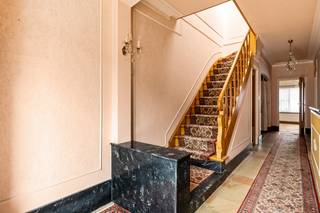Deze woning is erg centraal gelegen in het gezellige grensdorp Putte (Kapellen). U vindt winkels, scholen en het openbaar vervoer allemaal op wandelafstand, maar ook de dorpskernen van zowel Stabroek als Kapellen zijn vlot bereikbaar. Hoewel de woning gerenoveerd dient te worden, is ze aangenaam ruim en biedt ze heel wat mogelijkheden. Binnenkomen doet u via een ruime inkomhal op tegelvloer, voorzien van een nis voor vestiaire, een toilet en handige bergruimte onder de trap. Vanuit de inkomhal heeft u toegang tot de 2 slaapkamers op het gelijkvloers. Verder bevindt zich op de gelijkvloerse verdieping nog een grote polyvalente ruimte met achterliggend een overdekt koertje. Via de houten trap in de inkomhal bereikt u de 1e verdieping, waar u bovenkomt in een centrale hal op parketvloer. De L-vormige woonkamer, eveneens op parketvloer, is bijzonder ruim en kan genieten van heel wat lichtinval dankzij grote raampartijen. Grenzend aan de leefruimte bevindt zich nog een eenvoudige keuken op tegelvloer en een berging/wasplaats. Een achterdeur geeft vanuit de berging toegang tot de stenen buitentrap, dewelke leidt naar de toffe tuin. Op de 1e verdieping is verder nog een basic-ingerichte badkamer met douche en wastafel en een apart toilet aanwezig. Het perceel heeft een totale oppervlakte van 300m². De netjes onderhouden tuin is georiënteerd op het oosten en vormt een super tof plekje om heerlijk van de buitenlucht te genieten. Achteraan het perceel is nog een dubbele garage aanwezig, waarin u makkelijk uw wagen kan parkeren. Deze is langs de achterzijde te bereiken via een servitudewegenis.