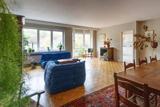 Wonen aan de Augustijnslei betekent wonen in een stukje Brasschaat waar het leven zachtjes meebuigt met het groen. Je zit hier letterlijk tegenover AZ Klina en toch maar 800 meter van het centrum — dicht bij alles, maar met rust die je niet overal vindt. De buurt is er eentje waar je te voet naar de bakker wandelt, in het weekend eens uitblust op een terras, of spontaan besluit om het Peerdsbos in te duiken.<br /><br />Leuke anekdote van de eigenaar: vlak bij vind je het Armand Reusensplein — een naamgenoot van de familie én oud-burgemeester van Brasschaat. In het Peerdsbos staat zelfs nog een obelisk van hem. Kleine geschiedenisles inbegrepen.<br /><br />Het appartement zelf ligt op de eerste verdieping van een kleinschalige residentie (1990), mét lift, en werd altijd met zorg onderhouden.<br />Daarbovenop is dit een energiezuinig appartement met EPC A.<br /><br />Gelijkvloers: een kleine autostaanplaats, een handige bergruimte én een tuin van 65 m² in gebruiksrecht — perfect voor wie graag wat buitenruimte heeft zonder het onderhoud van een volledige tuin.<br /><br />Verdieping 1: Via de gepantserde deur kom je in de inkomhal en bereik je alle ruimtes.<br />De grote woonkamer baadt in het ochtendlicht en biedt zelfs ruimte voor een forse eettafel — waar de vorige eigenaar moeiteloos vijf dochters en tien kleinkinderen rond verzamelde. Parket inbegrepen.<br />De keuken is instapklaar en wordt vergezeld door een royale technische berging: wasmachine, droogkast, voorraad, poetsgerief… alles krijgt hier zijn plek buiten je leefruimte.<br /><br />De master bedroom geeft toegang tot het terras met zicht op groen — ’s ochtends de ideale plek voor een stille start van de dag. Daarnaast is er nog een ruime tweede slaapkamer en een kleinere kamer die perfect dienstdoet als bureau, dressing of derde slaapkamer — ook met toegang tot het terras.<br />De badkamer is functioneel maar gedateerd — denk: een goeie basis waar je met wat creativiteit en vernieuwing iets heel moois van kan maken. Er is een douche, toilet en dubbele wastafel. Verder is er nog een apart gastentoilet.<br /><br />Een warm,licht en energiezuinig appartement, dichtbij het centrum en omringd door groen. Drie slaapkamers, een terras met uitzicht op het groen, een omheinde dorpstuin en een instapklare keuken. Perfect onderhouden en klaar voor iemand die zijn eigen toets wil geven aan dit appartement. Een plek waar licht, leven en Brasschaat mooi samenkomen.<br /><br />Interesse?<br />Mail naar info@wellimmo.net of bel +32 3 225 00 68<br /> 