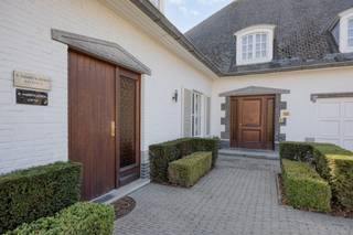 <h2><strong><strong>Karaktervolle villa met verwarmd zwembad, praktijkruimte en royale leefruimtes</strong></strong></h2><p>In het charmante Wespelaar, een groene deelgemeente van Haacht, bevindt zich deze stijlvolle villa op een royaal perceel van meer dan 21 are. Een woning met een uitzonderlijk gevoel van ruimte, veel privacy en tal van mogelijkheden. Gelegen vlak bij het centrum, op wandelafstand van winkels en het treinstation. Met een uitstekende verbinding naar Leuven en Mechelen combineert deze eigendom een rustige woonomgeving met een bijzonder vlotte bereikbaarheid.</p><p><br />De brede gevel en de imposante oprit geven de woning meteen een statige uitstraling. Achteraan ontvouwt zich een prachtig aangelegde tuin met veel privacy. Achter deze tuin bevindt zich het Arboretum, wat zorgt voor een bijzonder groene en rustige omgeving. Dankzij de zuidwestelijke oriëntatie geniet je hier volop van de zon: op het terras en aan het grote, verwarmde buitenzwembad. Dat zwembad wordt bovendien via een warmtepomp verwarmd, waardoor je het zwemseizoen moeiteloos kan verlengen. De ideale plek voor lange zomerdagen én -avonden.</p><p><br />Via de imposante inkomhal met gastentoilet betreed je de leefruimte die zonder twijfel het hart van de woning vormt. Met een oppervlakte van maar liefst 111 m² en een uitzonderlijke breedte van ongeveer 18 meter is dit een woonkamer van zeldzaam formaat. De terracotta tegelvloer en de houten balken aan het plafond geven de ruimte een uitgesproken karakter. Grote raampartijen zorgen voor een mooie lichtinval en verbinden het interieur met de tuin. Aansluitend bevindt zich de volledig ingerichte keuken met ruime eethoek. Vanuit de keuken is er toegang tot een praktische berging en de kelder.</p><p><br />Op de eerste verdieping, waar een parketvloer overal bijdraagt aan de warme sfeer, bevinden zich maar liefst vijf slaapkamers en twee badkamers. Alle ruimte dus voor een groot gezin, logeerkamers, hobbyruimtes of een extra bureau. Daarnaast beschikt de woning over bergkelders en zolderruimtes die extra opslagmogelijkheden bieden. Met een totale vloeroppervlakte van ongeveer 506 m², exclusief kelders, biedt deze villa een indrukwekkende hoeveelheid leefruimte.</p><p><br />Een bijzonder grote bijkomende troef is de praktijkruimte van ongeveer 50 m², die via een aparte inkom toegankelijk is. Deze beschikt over een eigen wachtruimte en sanitair en leent zich perfect voor vrije beroepen, zelfstandigen of ondernemers die wonen en werken willen combineren. Tegelijk biedt deze indeling interessante mogelijkheden voor zorg- of kangoeroewonen.</p><p><br />De woning behaalt een EPC-label C en tegelijk biedt de energieprestatie nog mogelijkheden voor verdere optimalisatie, voor wie de woning naar eigen smaak en comfortniveau wil moderniseren. De elektrische installatie is momenteel niet conform, maar kan volgens raming met een beperkte kost van ongeveer €3.000 in orde worden gebracht.</p><p><br />Kortom, een eigendom waar ruimte, privacy en functionaliteit samenkomen op een bijzonder groen perceel. Interesse om deze woning zelf te ontdekken? Geef JES dan gerust een seintje en we plannen graag een bezoekmoment in.</p><figure><div></div></figure><p></p>
