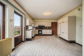 Gelegen in de Raatshovenstraat 73a in Landen, vinden we deze verrassend ruime halfopen bel-etagewoning met tal van mogelijkheden en een uitstekende ligging nabij alle voorzieningen. De woning biedt een bijzonder sterke basis en is ideaal voor wie op zoek is naar een pand dat men nog naar eigen smaak kan opfrissen en moderniseren. Op het gelijkvloers beschikt de woning over een zeer ruime inpandige garage met plaats voor maar liefst twee wagens. Daarnaast is er een uitzonderlijk grote, praktische kelderruimte die zich perfect leent als hobbyruimte, opslagplaats of extra polyvalente ruimte. De eerste verdieping verwelkomt u met een ruime inkomhal, voorzien van een apart toilet en vestiaire. De keuken biedt een aangenaam zicht op de tuin en vormt een mooie opportuniteit om te vernieuwen naar hedendaags comfort. Aansluitend bevindt zich de indrukwekkende leefruimte van circa 60 m², een doorlopende woon- en eetkamer met veel lichtinval en zicht op zowel de voor- als achterzijde, inclusief een balkon. Op de tweede verdieping vindt u een praktische bureauruimte, een tweede apart toilet en een badkamer. Verder telt de woning vier volwaardige slaapkamers met comfortabele oppervlaktes — ideaal voor gezinnen of wie extra ruimte wenst. Buiten is het minstens even indrukwekkend: de woning beschikt over uitzonderlijk veel parkeermogelijkheden met maar liefst zes parkeerplaatsen (voor de woning, achter de tuinpoort en op de oprit). De ruime tuin van circa 500 m² vormt een absolute troef en biedt een fenomenaal, rustgevend uitzicht op de omliggende velden. De ligging is bovendien ideaal: op korte afstand van het station, het centrum, openbaar vervoer en belangrijke invalswegen alsook de autostrade. Grotere steden zoals Hannuit, Tienen en Sint-Truiden zijn vlot bereikbaar. Ook liefhebbers van wandelen en natuur komen hier zeker aan hun trekken. Kortom, een woning met enorm potentieel voor wie ruimte, licht en ligging weet te combineren met de mogelijkheid om er een eigentijdse thuis van te maken. Interesse? Plan snel uw bezoek en ontdek zelf de mogelijkheden!