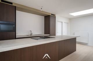<p>Bent u op zoek naar een ruim, lichtrijk en energiezuinig appartement met kwalitatieve afwerking?</p>
<p>Dit recent afgewerkte en instapklare appartement op de eerste verdieping van een kleinschalige residentie combineert comfort en een doordachte indeling voor hedendaags wonen.</p>
<p>Met een bewoonbare oppervlakte van 146 m² geniet u hier van royale leefruimtes en veel natuurlijk licht. De ruime leefruimte met lichtstraat vormt het hart van het appartement en sluit naadloos aan op de moderne, volledig uitgeruste keuken met aansluitende berging.</p>
<p>Vanuit zowel de leefruimte als de masterbedroom heeft u rechtstreeks toegang tot het ruime terras van 21 m², waar u in alle rust kan genieten van het buitenleven.</p>
<p>De nachthal biedt toegang tot twee volwaardige slaapkamers, een stijlvolle badkamer met inloopdouche, een aparte dressing, een praktische wasplaats en een afzonderlijk gastentoilet. Dankzij de kwalitatieve afwerking en de aanwezigheid van 9 zonnepanelen geniet u bovendien van extra wooncomfort en een lagere energiekost.</p>
<p><strong>Indeling en troeven:</strong></p>
<p>✅ 146 m² bewoonbare oppervlakte<br />✅ Ruime en lichtrijke leefruimte met grote lichtstraat<br />✅<span> </span><strong>Moderne, volledig afgewerkte keuken met aansluitende berging</strong><br />✅ 2 volwaardige slaapkamers en aparte dressing<br />✅ Stijlvolle badkamer met inloopdouche<br />✅ Aparte wasplaats en gastentoilet<br />✅<span> </span><strong>Ruim terras van 21 m² toegankelijk vanuit leefruimte en masterbedroom</strong><br />✅<span> </span><strong>9 zonnepanelen voor een energiezuinige woonst</strong><br />✅<span> </span><strong>Optioneel overdekte parkeerplaatsen aan te kopen</strong><br />✅ Rustige ligging met vlotte verbinding naar winkels, scholen en openbaar vervoer</p>
<p>Dit appartement is ideaal voor wie op zoek is naar ruim en comfortabel wonen met een moderne afwerking in een rustige omgeving.<br />Heeft u interesse? Contacteer ons gerust voor meer informatie of een persoonlijk bezoek.</p>
<p><em>Prijs excl. Btw en kosten. Verdere informatie verkrijgbaar via ons kantoor.<br /><br /></em><em>Sommige beelden werden aangeduid als visualisatie en zijn AI-gerenderde afbeeldingen die uitsluitend dienen ter illustratie van een mogelijke inrichting.</em></p>
