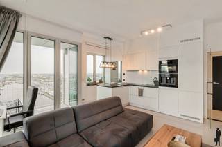 <strong>Wonen boven Antwerpen – Exclusief Panorama op de 19e verdieping</strong><br /><br />Op de 19e verdieping van Residentie Lichttoren bevindt zich dit uitzonderlijk en lichtrijk appartement met een adembenemend panoramisch uitzicht over Antwerpen.<br />De inkomhal geeft toegang tot een stijlvolle open leefruimte waar grote raampartijen het stadszicht centraal stellen. Aansluitend bevindt zich een inpandig terras, ideaal als beschutte buitenruimte in elk seizoen. De moderne open keuken is harmonieus geïntegreerd in het geheel. Het appartement beschikt over een ruime slaapkamer, een volwaardige badkamer en een privatieve berging op niveau -1.<br /><br /><strong>Bijzonderheden:</strong><br />- EPC score B<br />- Privatieve berging (-1)<br />- Autostaanplaats mee aan te kopen voor € 35.000