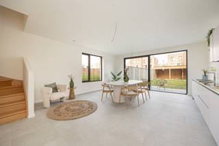 <p><span> </span></p><p><span>Droom je van een nieuwbouwwoning zonder aankoop onder btw-stelsel? Dan is dit je kans. In deze recent opgeleverde woning geniet je van alle hedendaagse comfort – warmtepomp, vloerverwarming, ventilatiesysteem, zonnepanelen en een E-peil onder 30 – waar je uitzonderlijk registratierechten op kan betalen. Gelegen in een rustige, doodlopende straat temidden het Boekenbergpark en Te Boelaerpark, woon je hier in een</span><span> </span><span>gezellige woongemeenschap en groene buurt met alle voorzieningen vlakbij. XL-staanplaats optioneel aan te kopen (€ 25.000).</span></p><p><span> </span></p><p><span>Licht, ruimte & hedendaags comfort</span></p><p><span>Van zodra je binnenkomt, valt de royale inkomhal op. De stijlvolle XL-tegelvloer loopt door over het volledige huis en zorgt voor een strak en tijdloos geheel. Er is meer dan voldoende plaats voor een vestiaire, terwijl aan de overzijde nog ruimte overblijft voor een speelhoek of een compacte thuiswerkplek. Links bevindt zich het gastentoilet met hangtoilet en lavabo.</span></p><p><span>Rechtdoor stap je de indrukwekkende leefkeuken binnen. Dankzij de hoekligging, het extra zijraam en het grote schuifraam naar de tuin baadt deze ruimte de hele dag in het natuurlijke licht. Binnen en buiten lopen hier naadloos in elkaar over. De moderne keuken is volledig uitgerust met Whirlpool-toestellen, waaronder een koelkast, diepvries met drie lades, combi-oven, vaatwasser, inductiekookplaat en een ruime spoelbak. Aansluitend bevindt zich de technische ruimte, waar alle technieken netjes zijn ondergebracht: ventilatiesysteem, aansluiting was-droogcombinatie, warmtepomp, omvormer van de zonnepanelen en de nutsvoorzieningen.</span></p><p><span> </span></p><p><span>Vier volwaardige slaapkamers en twee badkamers</span></p><p><span>Op de eerste verdieping bevindt zich de royale leefruimte aan de voorzijde van de woning. Dezelfde stijlvolle XL-tegelvloer loopt hier naadloos door en, in combinatie met de grote raampartijen, zorgt dit voor een aangename lichtinval en een heerlijk ruimtelijk gevoel. Achteraan vindt u de eerste slaapkamer: een comfortabele master bedroom met een prachtig uitzicht op de tuin dankzij de twee hoge raampartijen. De ensuite badkamer is stijlvol afgewerkt met kwalitatieve materialen en beschikt over een ruime inloopdouche, dubbel lavabomeubel met onderkasten en een grote spiegel.</span></p><p><span> </span></p><p><span>De tweede verdieping telt nog drie volwaardige slaapkamers, waardoor deze woning perfect is voor een gezin of wie extra ruimte zoekt. De nachthal baadt in het daglicht dankzij een lichtkoepel en geeft toegang tot een apart gastentoilet met handenwasser en de tweede badkamer. Net als de ensuite badkamer werd ook deze afgewerkt in dezelfde moderne, hoogwaardige stijl en uitgerust met een inloopdouche, ligbad en een dubbel lavabomeubel met onderkasten en spiegel.</span></p><p><span> </span></p><p><span>Groen wonen tussen twee parken</span></p><p><span>De ligging is een absolute meerwaarde. In deze rustige, doodlopende straat woon je tussen het Te Boelaerpark en het Boekenbergpark, met zijn bekende zwemvijver. Ideaal voor wie houdt van wandelen, lopen, fietsen of gewoon genieten van het groen. De woning maakt deel uit van een moderne woongemeenschap waar veel aandacht is besteed aan publieke ruimte en ontmoeting. Via de tuin heb je bovendien rechtstreeks toegang tot de gemeenschappelijke binnenruimte en speelzone. Winkels, scholen, supermarkten, tram, bus en een Velo-station bevinden zich vlakbij. Ook gezellige adresjes zoals Brasserie De Ekster liggen op wandelafstand, terwijl je dankzij de nabijheid van de Ring en belangrijke invalswegen snel in alle windrichtingen kan vertrekken.</span></p><p><span> </span></p>