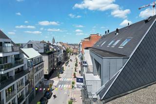 Dit instapklare duplexappartement met een bewoonbare oppervlakte van ca. 92 m² is gelegen op de vierde verdieping van residentie Grimbeert, midden in het bruisende centrum van Deinze. <br /><br />Bij het betreden van het appartement komt u terecht in de inkomhal met een apart gastentoilet en een bergruimte. De inkomhal geeft toegang tot de bijzonder lichtrijke leefruimte met een gezellige eet- en zithoek, die dankzij de grote raampartijen geniet van een aangename natuurlijke lichtinval. De open keuken sluit naadloos aan op de leefruimte. Aansluitend op de keuken bevindt zich een tweede berging. Vanuit de leefruimte heeft u toegang tot beide zuidwestgerichte terrassen met een totale oppervlakte van liefst 18,80 m², uitkijkend over de Tolpoortstraat. Via de trap bereikt u de bovenverdieping, waar de nachthal toegang biedt tot twee volwaardige slaapkamers en de badkamer, uitgerust met een enkele wastafel, een inloopdouche en een tweede toilet. <br /><br />In de ondergrondse verdieping is er een kelderberging aanwezig, inbegrepen in de prijs. Daarnaast is er ook nog een ondergrondse autostaanplaats aanwezig die verplicht dient aangekocht te worden voor de prijs van 28.500 euro. <br />CV op aardgas / EPC 124 (B) / EK conform <br />Benieuwd? Een afspraak kan via guillian@landbergh.be of 09 278 78 79.