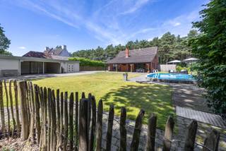 Op een rustige en unieke, groene locatie in Rhoode te Oud-Turnhout bevindt zich deze vrijstaande gezinswoning met vier slaapkamers, twee badkamers, zwembad en een ruim bijgebouw met carport. Een eigendom met veel ruimte en mogelijkheden voor wie op zoek is naar een woning die verder naar eigen smaak gemoderniseerd kan worden.
De woning is praktisch ingedeeld en biedt verrassend veel ruimte. Op het gelijkvloers vinden we een inkomhal, een ruime en lichtrijke leefruimte, keuken, slaapkamer, badkamer en een bijkomende polyvalente ruimte.
De living en keuken werden in 2010 vernieuwd en vormen een aangenaam geheel met veel natuurlijke lichtinval en contact met de tuin. De keuken werd uitgevoerd in mooie materialen en sluit aan op een handige wasplaats/berging.
Een belangrijke troef is de aanwezigheid van een volwaardige slaapkamer en badkamer op het gelijkvloers. Daarnaast is er nog een ruime polyvalente kamer, thans met een tweede keuken, welke kan dienen als praktijkruimte, inwonende ouder of als kantoor aan huis met aparte inkom.
Op de eerste verdieping bevinden zich nog drie slaapkamers en een tweede badkamer met douche, lavabo en toilet. Deze badkamer werd vernieuwd in 2004.
Verder beschikt de woning over een praktische kelder, bereikbaar vanuit de leefruimte.
Ook buiten heeft dit eigendom heel wat te bieden. De woning beschikt over een ruime tuin, zwembad, overdekt terras en voldoende parkeergelegenheid. Het afzonderlijke houten bijgebouw met carport en afgesloten berging biedt bovendien heel wat extra plaats voor wagens, fietsen, tuinmateriaal of hobby's.
De woning werd steeds goed onderhouden, maar biedt tegelijk nog mogelijkheden voor verdere modernisering. Hierdoor is ze bijzonder interessant voor kandidaat-kopers die ruimte en een groene ligging zoeken en de woning op termijn verder naar eigen smaak willen aanpassen.
Troeven:
- zowel via achterzijde van de woning als voorzijde zicht op blijvend groen
- 4 slaapkamers
- slaapkamer en badkamer op het gelijkvloers
- 2 badkamers
- vernieuwde living en keuken
- badkamer verdieping vernieuwd
- polyvalente ruimte, praktijk, inwonende ouder of kind, kantoor aan huis
- kelder
- zwembad
- ruim bijgebouw met carport en berging
- ruime parkeermogelijkheden
P-score A en G-score A