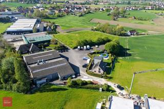 Nijverheidsgebouwen met private toegangsweg en alleenstaande woning (263m² vloeroppervlakte met inkomhall, living met zitruimte, ingerichte keuken, 5 slaapkamers, 2 badkamers, dressingkamer, wasplaats, berging. Laatste verbouwing 2009. Airco en screens, deels vloerverwarming). Industriegebouwen 2 x 660m² met sectionale poorten, burelen, kitchenette, kleedruimte en refter (bouwjaar 1994)