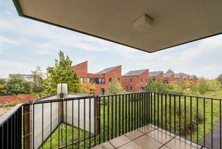 <p><span>Geen zin in verbouwen, schilderen of verrassingen? Dan zit je hier goed. Dit appartement uit 2017 ligt in een jonge woonwijk waar kinderen nog op straat spelen en buren elkaar kennen. Je woont hier rustig, met een supermarkt om de hoek, het Boekenbergpark vlakbij en een Velostation letterlijk voor de deur.</span></p><p><span> </span></p><p><span>Binnenkomen en je jas neergooien</span></p><p><span>De inkomhal is slim ingedeeld voor een vestiaire. Verderop opent het appartement zich meteen naar de leefruimte. Geen verloren vierkante meters hier, maar een logische indeling waarbij koken, eten en ontspannen mooi in elkaar overvloeien.</span></p><p><span>De woonkamer krijgt langs verschillende kanten daglicht binnen dankzij de hoekligging. Terwijl je aan tafel zit, kijk je uit op het groen en de jonge wijk rondom je. Geen gevel op twee meter afstand, maar een open gevoel dat je in veel appartementen mist.</span></p><p><span>De keuken houdt het strak en eenvoudig, met witte greeploze kasten, een inductiekookplaat, combi-oven, vaatwasser en flink wat opbergruimte. Achteraf verdwijnen de boodschappen gewoon in de aansluitende berging, zodat het werkblad netjes blijft.</span></p><p><span> </span></p><p><span>Koffie buiten, zelfs als het regent</span></p><p><span>Op het overdekte terras zit je beschut en toch buiten. Groot genoeg voor een tafeltje en enkele stoelen. Dankzij het vele groen in de omgeving voelt het hier verrassend rustig aan voor een locatie zo dicht bij de stad.</span></p><p><span>Verder zijn er twee slaapkamers. De grootste biedt voldoende plaats voor een dubbel bed en een ruime kast. De tweede kamer doet even vlot dienst als kinderkamer, bureau of dressing.</span></p><p><span>De badkamer kreeg een verzorgde, tijdloze afwerking met een ruime inloopdouche en een dubbel lavabomeubel. Geen ochtenddiscussies meer over wie eerst aan de wastafel staat.</span></p><p><span> </span></p><p><span>Praktisch wonen</span></p><p><span>Ook aan de minder zichtbare zaken werd gedacht. Er is een aparte plek voor wasmachine en droogkast, een ruime kelderberging voor spullen die je niet dagelijks gebruikt en een ondergrondse parkeerplaats die verplicht mee aan te kopen is. Thuiskomen en niet meer rondjes rijden op zoek naar een vrije plek: het lijkt een detail, tot je het gewoon bent.</span></p><p><span> </span></p><p><span>Jong, groen en verrassend goed verbonden</span></p><p><span>Deze buurt trekt vooral jonge gezinnen en starters aan. Kinderen spelen in de buurt, de speeltuin ligt vlakbij en voor een wandeling hoef je niet verder dan het Boekenbergpark. Met tram, bus, velo en de Ring vlakbij geraak je bovendien snel waar je moet zijn, zonder midden in de drukte te wonen.</span></p><p><span><br /><br /></span></p>