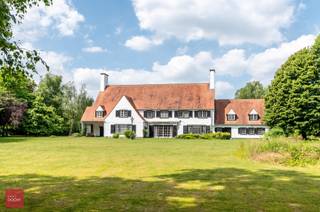 Villa gelegen op perceel van +/- 9.600m², bestaande uit inkomhal, bureel, living, eetplaats, keuken, bijkeuken (wasplaats), dagelijkse woonkamer (tv-kamer), dubbele garage, 5 slaapkamers, 3 badkamers, dressing, ruime zolder met vaste trap, kelders, terrassen, berging en zuidgerichte tuin. Mogelijkheid +/- 2ha landbouwgrond bij te kopen.<br />