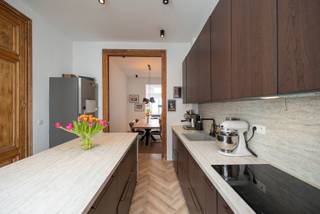 <p>"We hebben hier met ontzettend veel plezier gewoond. Het is zo’n plek waar je je meteen thuis voelt, waar het licht elke dag weer anders binnenvalt en waar oud en nieuw mooi samenkomen.</p>
<p>Wat we misschien nog wel het meest gaan missen, is het leven hier in de buurt. Op een zonnige dag wandelden we graag even naar Bar Chapel, of spraken we af met vrienden bij Bar Noord of Bar Leon. Het zijn van die fijne plekken waar je als ouder rustig iets kunt drinken terwijl de kinderen zich vermaken.</p>
<p>Ook het zwembad in de Veldstraat ligt vlakbij, ideaal voor een frisse zwembeurt. En als je van eten houdt, zit je hier echt goed: in de buurt vind je smaken van over de hele wereld, altijd wel iets nieuws om te ontdekken.</p>
<p>Tegelijk is het hier verrassend rustig wonen. Een plek waar je even kan ontsnappen aan de drukte, maar toch alles binnen handbereik hebt en zo de stad in bent of de baan op kan."</p>