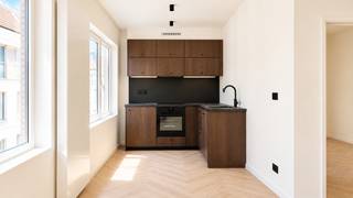 Dit gerenoveerde 1-slaapkamerappartement van ca 52 m² bevindt zich op de derde verdieping van een volledig gerenoveerd appartementsgebouw in het hart van Antwerpen. Dankzij de centrale maar rustige ligging bevinden winkels, gezellige horeca en openbaar vervoer zich op wandelafstand.<br /><br />De aangename leefruimte is praktisch ingedeeld en biedt voldoende plaats voor zowel een zit- als eethoek. Aansluitend bevindt zich de open keuken in donkere eik, die het geheel een warme en hedendaagse uitstraling geeft. De keuken is volledig uitgerust met alle nodige toestellen. Ook de aansluiting voor de wasmachine is hier voorzien.<br /><br />Aan de rustige achterzijde bevindt zich de ruime slaapkamer van ca 12 m².<br /><br />De badkamer is modern en functioneel ingericht en beschikt over een inloopdouche met regendouche, een lavabomeubel en een toilet.<br /><br />Verder beschikt het appartement over een privatieve kelderberging, een gemeenschappelijke fietsenstalling en een gemeenschappelijk afvallokaal.<br /><br />Gemeenschappelijke lasten: 30 Euro per maand<br />Provisie waterverbruik: 35 Euro per maand<br />Gas en elektriciteit zijn individueel af te sluiten door de huurder.<br /><br />Beschikbaar vanaf 1 september 2026.