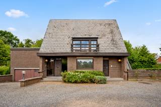 Deze bijzonder knappe en originele woning geniet van een uitzonderlijke ligging in het charmante Hoegaarden, een gemeente die bekendstaat om haar groene karakter, aangename woonomgeving en uitstekende bereikbaarheid. De woning werd met veel aandacht voor architectuur, ruimte en licht ontworpen en biedt een unieke woonbeleving voor wie op zoek is naar een eigendom met karakter.<br /><br />De grote, mooie aangelegde tuin vormt een absolute blikvanger en biedt een uitzonderlijk weids uitzicht dat zorgt voor een gevoel van rust, ruimte en privacy. Een zeldzame troef die deze woning een bijzonder exclusieve uitstraling geeft.<br /><br />Binnen ontdekt u royale leefruimtes met onder meer een ruime eetkamer en een gezellige zitkamer, ideaal voor sfeervolle familiemomenten of het ontvangen van gasten. De woning beschikt bovendien over vijf volwaardige slaapkamers, waardoor ze perfect geschikt is voor een groot gezin of voor wie extra ruimte wenst.<br /><br />Een bijzondere meerwaarde is het volledig afgescheiden gedeelte voor een vrij beroep of zelfstandige activiteit. Dit omvat een aparte inkomhal met wachtkamer, een bureel en een praktijkruimte, waardoor wonen en werken op een professionele en comfortabele manier gecombineerd kunnen worden.<br /><br />De woning dient opgefrist/gerenoveerd te worden om ze volledig af te stemmen op de hedendaagse woonnormen van 2026. Dankzij haar uitzonderlijke architectuur, de royale volumes, de unieke tuin en de veelzijdige indeling biedt deze eigendom een bijzonder potentieel om uit te groeien tot een hedendaagse droomwoning met behoud van haar originele karakter en uitstraling.<br /><br />Een zeldzame kans voor wie op zoek is naar een karaktervolle woning op een prachtige locatie in Hoegaarden.