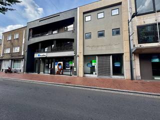 Op een strategische ligging langs de Roeselaarsestraat 64 in Izegem bevindt zich dit instapklare handelspand van ca. 131 m². Dankzij de uitstekende visibiliteit en centrale bereikbaarheid vormt dit pand de ideale uitvalsbasis voor wie professioneel wil groeien op een zichtlocatie.<br /><br />Bij het binnenkomen wordt u verwelkomd in een verzorgde inkom- en wachtruimte die meteen vertrouwen uitstraalt naar uw cliënteel. Aansluitend bevinden zich meerdere afzonderlijke bureelruimtes, perfect geschikt voor consultaties, meetings of administratieve doeleinden. Achteraan ontdekt u een ruime, polyvalente open ruimte die zich flexibel laat indelen volgens uw activiteit.<br /><br />Het pand is bovendien uitgerust met alle nodige praktische voorzieningen, waaronder een kitchenette, sanitaire ruimtes (inclusief aangepaste faciliteiten) en voldoende bergruimte. De aanwezige technische installaties dragen bij tot een vlot en comfortabel gebruik.<br /><br />Een absolute troef is de privatieve stadstuin, die niet alleen zorgt voor extra lichtinval, maar ook voor een aangename en rustige werkomgeving – een zeldzaam pluspunt in een commerciële setting.<br /><br />Op zoek naar een commercieel pand met uitstraling én mogelijkheden? Contacteer ons vandaag nog voor meer informatie of een bezoek. Wij begeleiden u graag verder.<br /><br />