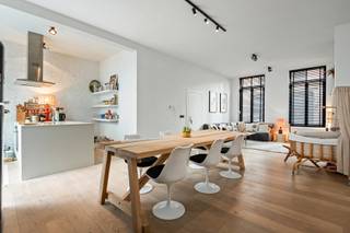 On the ground floor, one enters the apartment. The spacious living area with wooden floors and high ceilings immediately provides a pleasant sense of space and light. Adjacent is the open-plan kitchen, equipped with all necessary appliances and with direct access to a cosy inner courtyard of approx. 20 m².

The apartment further comprises a separate guest toilet, a second room that can ideally serve as an office or dressing room (currently fitted with a washing machine and dryer), and a spacious master bedroom. The bathroom is fitted with a double washbasin and a bathtub with shower function.

The apartment offers all modern comforts. Monthly common charges amount to €25 (excluding gas, water and electricity). Preferably, the apartment is rented furnished, at an additional cost of €125 per month.