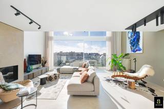 À Duinbergen, à quelques pas de la digue et du club de voile RSBC, se trouve cet appartement mezzanine exceptionnel d’environ 215 m² (façade 7 m) dans la résidence récente Hampton Beach.<br /><br />Disposition :<br />6ᵉ étage : hall d’entrée avec vestiaire, toilette invités et débarras. Séjour spacieux et lumineux avec grandes baies vitrées donnant sur la terrasse plein sud et vue dégagée sur le quartier des villas. À l’arrière, cuisine ouverte équipée avec îlot en pierre naturelle et accès à une seconde terrasse.<br />7ᵉ étage : trois grandes chambres. Suite parentale avec salle de douche attenante, chambre d’amis pour lit double, et chambre mezzanine avec dressing ouvert et salle de douche (raccords lave-linge/sèche-linge). Sur le palier : troisième salle de bains avec baignoire, toilette et lavabo. Étage accessible également par l’ascenseur commun.<br /><br />Finitions haut de gamme : armoires sur mesure en barnwood, sols en enduit de chaux, parquet à l’étage, meubles de salle de bains en noyer et chêne brut. Vitrage solaire au sud et stores électriques pour un confort optimal.<br />Cave privée avec supports à vélos. Possibilité d’acquérir un double garage dans l’immeuble (ascenseur pour voitures).