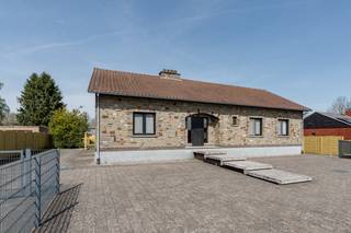 Deze karaktervolle bungalow met 3 slaapkamers, grote geïsoleerde zolder en ruime tuin op perceel van 14a18ca vinden we terug op de Fabrieksstraat 11 te Hamont-Achel op een steenworp van de Nederlandse grens.<br /><br />Deze woning, gebouwd in 1983, bevindt zich op een mooi perceel van 1418 m² en valt meteen op door haar authentieke gevel, ruime oprit en verzorgde uitstraling. Dankzij de grote voortuin en brede oprit is er ruim plaats voor meerdere wagens, aangevuld met een recent geplaatste carport (2021).<br />Indeling;<br />Bij het betreden van de woning komt u terecht in een ruime inkomhal met toegang tot de verschillende leefruimtes.<br />De leefruimte straalt karakter uit dankzij de natuurstenen vloeren, houten accenten en een gezellige open haard, wat zorgt voor een warme en aangename sfeer. Aansluitend bevindt zich een lichtrijke eetruimte met zicht op de tuin.<br />De keuken werd vernieuwd in 1990 en beschikt over een praktische indeling met veel werkruimte en een centraal eiland. Vanuit de keuken is er een rechtstreekse toegang naar buiten.<br />Verder beschikt de woning over 3 volwaardige slaapkamers, een ruime badkamer, apart toilet, praktische bergruimtes<br />Een kelderverdieping met garage en zeer veel opslagruimte dewelke ook vanuit de tuin te bereiken is.<br />Grote geïsoleerde zolder — enorm uitbreidingspotentieel<br />Een van de absolute troeven van deze woning is de zeer ruime zolderverdieping.<br />De zolder werd reeds volledig geïsoleerd en biedt een indrukwekkend volume. Deze ruimte kan perfect ingericht worden als:<br />Extra slaapkamers of een zeer ruime hobbyruimte, speelzolder of multifunctionele ruimte.<br />Dit maakt deze woning bijzonder interessant voor gezinnen of kopers die extra woonruimte wensen te creëren.<br />De woning heeft ook een ruime tuin met serre en bijgebouwen<br /><br />Troeven:<br /><br />Zonnepanelen geplaatst in 2022 (5940 Wp)<br />Thuisbatterij aanwezig<br />Gasketel vernieuwd in 2007<br />Dakisolatie aanwezig<br />Daarnaast beschikt de woning over een asbestveilig attest, wat een extra zekerheid biedt voor toekomstige eigenaars.<br />Troeven van deze woning<br />Open bebouwing op 1.418 m² perceel<br />3 slaapkamers<br />Zeer grote geïsoleerde zolder met uitbreidingsmogelijkheden<br />Kelder met garage en veel opslagruimte<br />Karaktervolle woning met authentieke elementen<br /> 