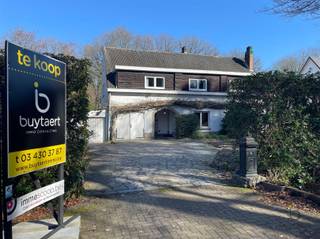 <p><span>Veel renovatiepotentieel in ruime rustig gelegen familiewoning midden in het groen!</span></p><p><span>Ideaal gelegen in een rustige, residentiële wijk op de grens van Schilde en Zoersel, met een goede bereikbaarheid en nabijheid van scholen, winkels en openbaar vervoer.  </span></p><p><span>Deze vrijstaande karaktervolle familie-woning op een perceel van 2500m² met zes slaapkamers en heel wat mogelijkheden aanpasbaar naar uw persoonlijke stijl en wensen is aan een hedendaagse renovatie toe. </span></p><p><span>De ruime inkomhal (16m²) met houten trap en gastentoilet geeft toegang tot de living en de keuken. </span></p><p><span>De grote leefruimte (67m²) met veel ramen en natuurlijk daglicht, alsook een centrale schouw met open gashaard waardoor een gezellige warmte kan gecreëerd worden. </span></p><p><span>Achterliggend heb je aansluitend een polyvalente ruimte en bergplaats met directe toegang tot de tuin en het terras. </span></p><p><span>Naastgelegen, de keuken met ontbijthoek (30m²) en directe doorgangen naar de tuin en garage. Het huis is uitgerust met een inpandige garage, een tweede aangebouwde garage en een serrekamer.</span></p><p><span>Op de eerste verdieping bevinden zich ter hoogte van de eerste nachthal met kastenwand drie ruime slaapkamers (23m², 16m² en 12m²) en een badkamer (18m²) met dubbel lavabomeubel, bad, douche en toilet. </span></p><p><span>Vervolgens werd in een aansluitende polyvalente ruimte van 50 m² een tweede nachthal, drie slaapkamers en een tweede badkamer gerealiseerd.</span></p><p><span>Een verdieping hoger, bereikt men een opbergzolder via een luik. </span></p><p><span>In de grote tuin met terras, tuinhuis en uitgebouwd met een zwembad dat vanaf de jaren '70 in gebruik werd genomen, is het genieten van een groene omgeving. Achteraan in de tuin was er destijds een tennisveld dat nu begroeid is.</span></p><p><span>Mits aanpassing- en modernisering werken kan je hier uw eigen pareltje van maken, een woning met mogelijkheden en verrassende mooie ruimten.  </span></p><p><span>Bijzonderheden: zeer centraal, rustig gelegen, ruimtelijk ingedeeld, grote groene tuin.</span></p><p><span>Neem contact op voor meer informatie of een bezichtiging! <span>www.buytaertimmo.be</span></span></p><p><span> </span></p>