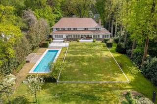 <p>Op wandelafstand van de winkels in het centrum, aan mooie laan én op een prachtig perceel grond (<strong>ca. 4.899 m²)</strong>, zeer sfeervolle en instapklare villa met achterliggende <strong>guesthouse (heden pilatesstudio + conciërgewoning) en buitenzwembad.<br /></strong><br /><strong>De gelijkvloerse verdieping: </strong></p>
<p>- Hal/entree op terracotta vloer met gastentoilet en handenwasser <br />- Een royale woonkamer (ca. 68m²) op parket met hout gestookte open haard en grote raampartijen met zicht op de tuin<br />- Een leefkeuken (ca.58m²) op terracotta vloer met gashaard, <strong>2 keukeneilanden</strong> met dubbele gootsteen, inductie kookvuur, vaatwasser en bargedeelte (4 pers.), kastenwand met 2 koelkasten+diepvries (Neff), 2 ovens en een Miele stoomoven.<br />- Een bureau/tv kamer (ca. 31m²) op parket met hout gestookte open haard en inbouwkasten<br />- Een slaapkamer (ca.18m²) op terracotategel met inloopdouche, toilet en lavabo<br />- Zij-ingang via de garage: een inpandige garage (ca.47m²) voorzien van 2 elektrische poorten, 2 uitgietbakken, en ingemaakte kasten, elektra, <br />water en verwarming. <br />- Een kelder (ca.100m²) met o.a. <strong>wijnkelder</strong>, technische ruimte, waterontharder en veel opslagruimte <br /><br /><strong><u>De eerste verdieping is op visgraatparket: <br /></u></strong>- Een nachthal op parketvloer<br />- Een <strong>royale hoofdslaapkamer (ca.27m²) met gashaard en royale dressing (ca.36m²)</strong><br />- Een ensuite marmeren hoofdbadkamer (ca.13m²) met dubbele lavabomeubel, ligbad, inloopdouche en toilet, ingemaakte kast<br />- Twee slaapkamers (ca.28m² en 17m²) <br />- Een vijfde slaapkamer (ca.13m²) met douchekamer (ca. 6m²), toilet en lavabo<br />- Een badkamer (ca.13m²) met ligbad, inloopdouche, dubbele lavabo en toilet<br /><br /><strong><u>De tweede verdieping is volledig voorzien van visgraatparket en onderliggende houtroostering:</u></strong><br />- Een zesde slaapkamer (ca.22m²) met ensuite douchekamer voorzien van inloopdouche, toilet en lavabo<br />- hobbykamer/wasplaats/berging met ingemaakte kastenwand<br /><br /><strong>Tuinhuis/guesthouse:</strong><br />Keuken voorzien van Siemens gasfornuis, gootsteen, ijskast. Douchekamer voorzien van douche, lavabo, toilet, sauna zowel gewone sauna als infraroodsauna en fitness/pilatesruimte voorzien van sporthal en balletbar. Via vaste trap naar bovenliggende verdieping waar zich de slaapkamer bevindt. <br /><br /><strong><u>Vernieuwingen:</u></strong></p>
<p>In 2010: totaalverbouwing.<br />In 2022 is het rolluik alsook de motor van het zwembad vernieuwd, alsook zijn de parketvloeren gelegd op de 1<sup>ste</sup> en 2<sup>de</sup> verdieping, keuken deels vernieuwd, OH in de keuken geplaatst, deels nieuwe terracotategel in de keuken, etc.<br />In 2023: is de elektra herkeurd<br />In 2024: is het huis volledig herschilderd (plafonds en muren) incl. de dakgoten.</p>
<p><strong><u>Algemeen:</u></strong></p>
<p>- Verwarming op gas (Remeha) d.m.v. radiatoren en vloerverwarming in het bureel, de living en deels in de keuken. Optima boiler.<br />- Alarmsysteem d.m.v. ruimtedetectie, rookmelders aangesloten op de alarminstallatie, veiligheidsdeur, domotica, waterontharder, rolluiken, vliegenramen, blokdeuren.<br />- Oprit te bereiken via automatische toegangspoort<br />Kelder bestaande uit kelder (berging) en kruipkelder, gescheiden rioleringssysteem, regenwaterput (niet in gebruik)<br />- Centrale ligging t.o.v. het centrum, openbaar vervoer, winkels en scholen</p>
<p><strong><u>Tuin:</u></strong></p>
<p>Prachtig aangelegde diepe omheinde tuin welke volledige privacy biedt.<br />Verwarmd buitenzwembad (chloor + ionisatie ) van 14m op 4m en ca. 1,5m diep. (vernieuwd rolluik en motor).<br />Diverse terrassen zowel bij het bijgebouw, als bij de villa waaronder eveneens een overdekt terras met vaste zitbank, heatstrip en muziek, zonnetent.<br />Achterliggende houtberging, tweede tuinhuis<br />Sproei-installatie</p>