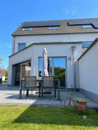 Deze prachtige halfopen bebouwing, gebouwd eind 2014, combineert ruimte, comfort & energiezuinig wonen. Met een EPC-label A, 10 zonnepanelen en kwalitatieve afwerking is deze woning volledig instapklaar.<br /><br />Bij aankomst beschikt u over een grote inpandige garage met elektrische poort en 2 autostaanplaatsen. Via de ruime inkomhal met ingemaakte kasten & afzonderlijk gastentoilet betreedt u de woning. De woning is uitgerust met een centrale alarminstallatie.<br /><br />De lichtrijke woon- en leefruimte vormt met de open keuken het hart van de woning. De keuken is uitgerust met kwalitatieve toestellen en biedt alle comfort voor dagelijks gebruik. De aanwezigheid van vloerverwarming, airconditioning & professioneel geplaatste zonnewering houdt de leefruimte steeds op ideale temperatuur.<br /><br />Via de leefruimte heeft u toegang tot het ruime terras en de volledig omheinde, onderhoudsvriendelijke tuin met tuinhuis. Een ideale plek om in alle rust te genieten.<br /><br />De eerste verdieping bereikt u via een stijlvol afgewerkte natuurstenen trap met sfeerverlichting. Hier bevinden zich 2 ruime slaapkamers, waaronder een master bedroom met ingemaakte kleerkast. Daarnaast is er een praktische wasplaats met aansluitingen voor wasmachine en droogkast en voldoende bergruimte. Op de nachthal bevindt zich een afzonderlijk toilet. De moderne, lichtrijke badkamer is uitgerust met ligbad, inloopdouche en badkamermeubel met dubbele wastafel. Ook deze verdieping beschikt over airconditioning.<br /><br />Via dezelfde hoogwaardige trap bereikt u de 2e verdieping. Hier bevinden zich nog 2 slaapkamers. Eén slaapkamer biedt de mogelijkheid om een aangrenzende dressing of een 5de slaapkamer in te richten.<br /><br />De woning geniet een uitstekende ligging, op korte afstand van Aalst en heeft een vlotte bereikbaarheid. Tegelijk ervaart u hier de rust en het groene karakter van Hofstade.<br /><br />Als extra troef werd de woning recent professioneel geschilderd. Interesse? Neem gerust contact op voor meer info of een bezichtiging.